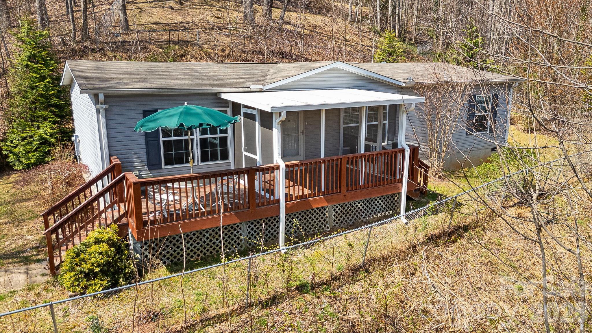 Welcome to 403 Youngs Gap Road, a well-maintained 3-bedroom, 2-bathroom double-wide offering comfortable one-level living in a peaceful, private setting. Inside, you’ll find a functional layout with a bright living area, a spacious kitchen with room for gatherings, and well-sized bedrooms that make the home feel both practical and inviting. The setting here really stands out. The yard has been cleared, opening up the space and making it highly usable while still maintaining privacy. A newly added screened-in porch creates a great spot to relax and enjoy the surroundings. The property also features a fenced pasture area, ideal for animals or flexible outdoor use, along with two outdoor storage sheds for tools, equipment, or hobbies. There is plenty of room for gardening, entertaining, or simply enjoying the land. This property offers a great blend of space, privacy, and functionality while still being within a convenient drive to Asheville, Arden, and the surrounding areas.