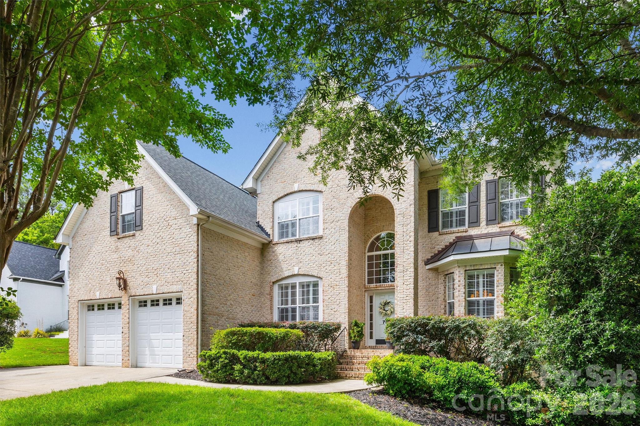 Beautifully maintained home with a dramatic two-story foyer highlighted by a grand staircase with wrought iron balusters. The designated office features French doors, custom built-ins, and plantation shutters and the formal dining room offers a tray ceiling, wainscot molding, and plantation shutters. The chef’s kitchen includes double ovens, gas range, stainless steel appliances, breakfast bar, pantry, abundant cabinetry, and extensive prep space ideal for everyday living and entertaining. The main-level primary suite offers a private retreat with a custom walk-in closet featuring built-in cabinetry and shelving, double vanity, garden tub, and glass-enclosed shower. Upstairs includes a spacious bonus/loft area, 4 additional bedrooms, and 2 full baths providing flexible space for guests, work, or recreation. Additional highlights include surround sound speakers, security system, oversized extra-deep two-car garage, extended exterior parking pad along the left side of the home, large walk-in crawlspace for storage, irrigation system, fenced yard, large back deck, and a playhouse/treehouse. Enjoy wooded privacy just beyond the back gate with trails and open space leading toward the golf course. Located in the waterfront recreational community of Tega Cay with access to Lake Wylie, marina, golf course, clubhouse, pool, tennis and pickleball courts, walking trails, and award-winning Fort Mill schools.