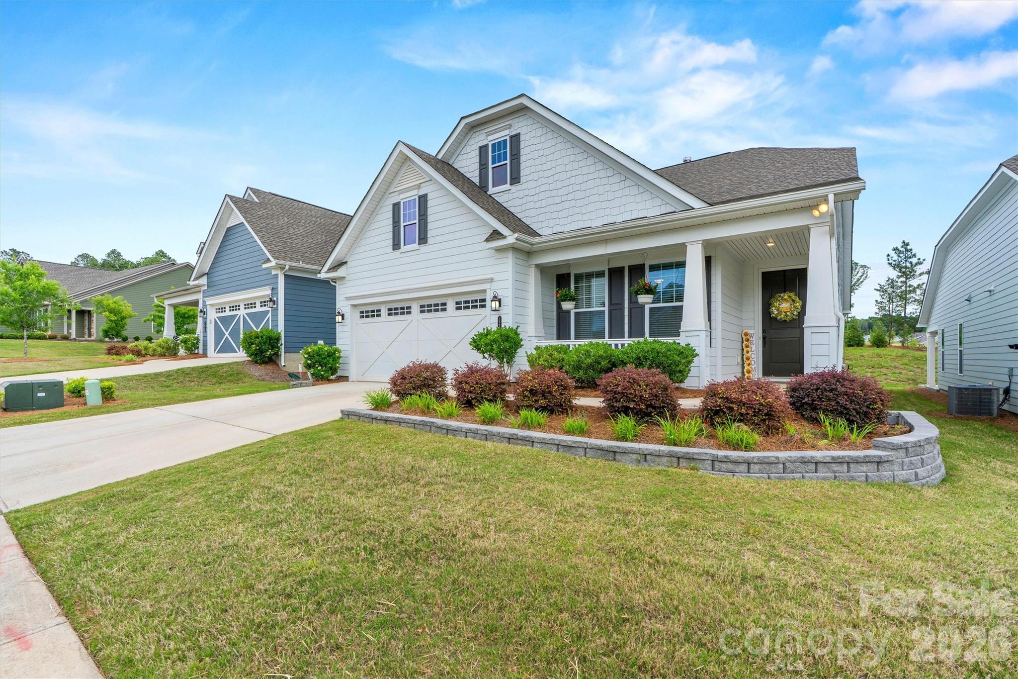 PRICED TO SELL!  This award-winning DOGWOOD model offering 1,815 sq ft with 3 bedrooms and 2 full baths, thoughtfully designed with both comfort and style in mind. This home features a 4’ garage extension plus added floored attic storage - ideal for keeping everything organized. Inside, you’ll find LVP flooring throughout the main living areas and tile in the wet spaces, along with a stunning floor-to-ceiling stone VENTED gas fireplace with a cedar mantle anchoring the main living space. The well-appointed kitchen showcases a stainless steel appliance pkg, Gas range, granite countertops, custom tile backsplash, and under-cabinet lighting. The spacious primary suite offers a tray ceiling and a beautifully designed ensuite bath complete with a dual-sink vanity with granite countertops, a soaking tub, and a frameless walk-in shower. Outdoor living truly sets this home apart - enjoy a covered rear porch, extended concrete patio, and fenced backyard with exceptional privacy. With no home directly behind, a natural berm, and a retention pond as your rear neighbor, this setting is peaceful and hard to find. A charming covered front porch adds even more curb appeal. Don’t miss your chance to enjoy low-maintenance living with lawn maintenance, security system, cable, and high-speed internet included, all within an active, resort-style 55+ community offering a full-time Lifestyle Director, indoor and outdoor pools, sports courts, trails, dog parks, and a 17,000+ sq ft clubhouse.