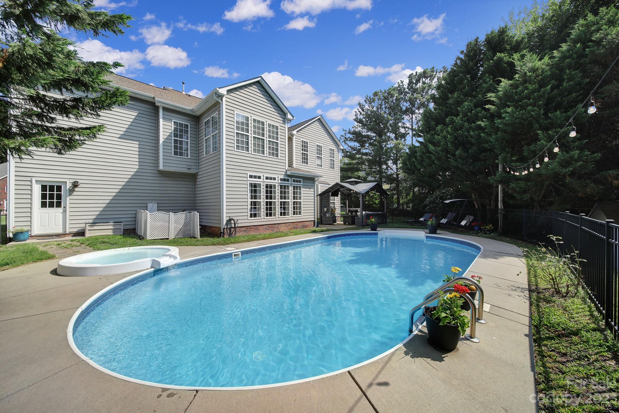 Welcome home to your oasis in Fort Mill. This home boasts square footage as well as a backyard made for entertaining w/ an in-ground heated pool & hot tub & large patio area. As soon as you step through the front door, you'll be enamored w/ a tranquil feeling as you gaze through the main level finding the formal dining room, an office w/ french doors, & a very cozy living room with coffered ceiling & gas fireplace. The large, open kitchen has plenty of storage & room to cook and hang out with an oversized island & brand new Silestone countertops. Notice the fresh modern feel from the brand new LVP floors, new carpet upstairs, & new paint throughout the entire home as the natural light pours in. Head up the grand staircase to find all of the bedrooms, including the primary suite, and the laundry room. You'll also be impressed by the large bonus room for even more living space. Just beyond the back fence of the pool area, you'll also find a playset for the kids & shed for yard tools.