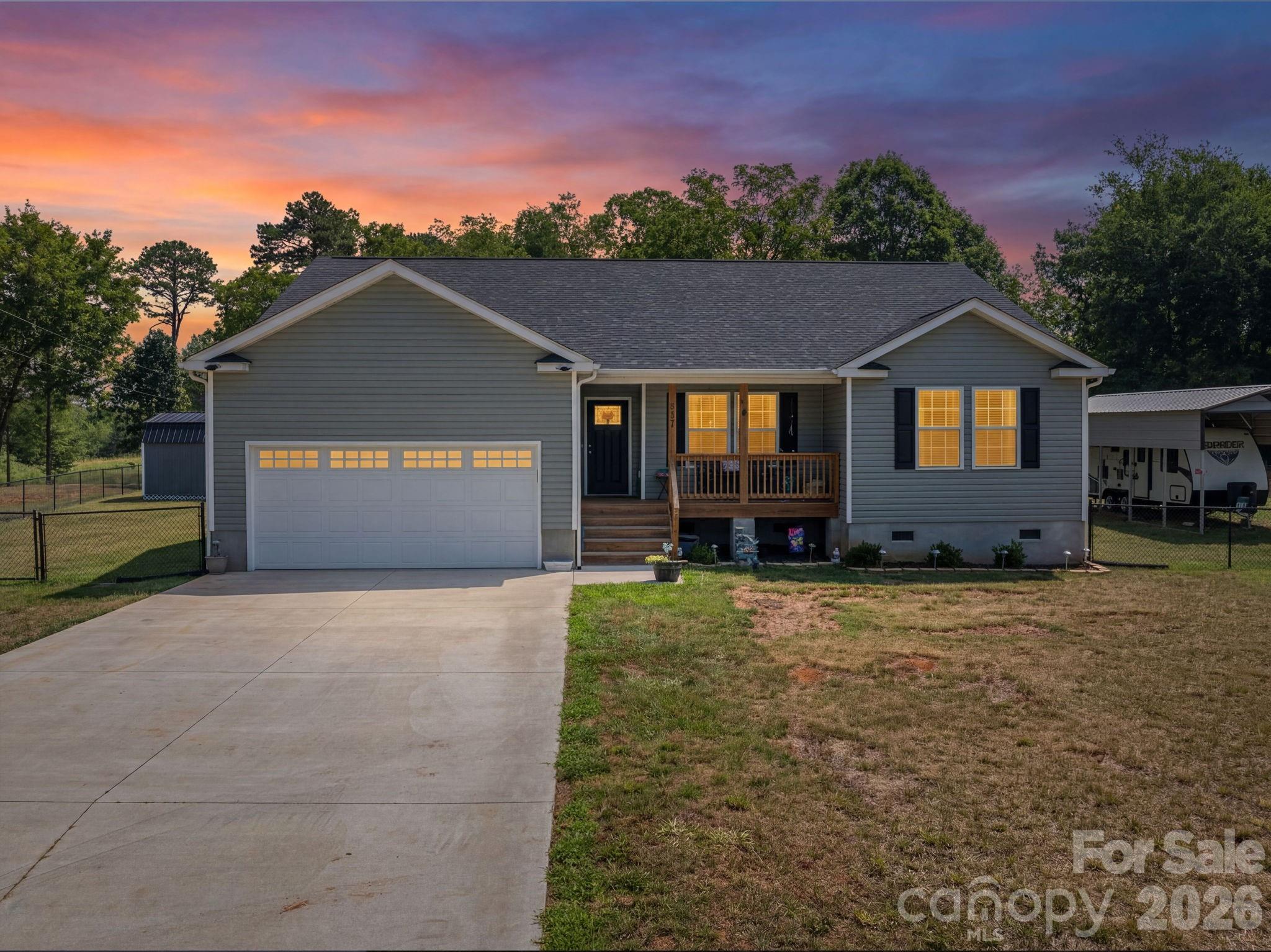 Welcome to peaceful country living in this beautiful 2024-built home, perfectly situated on 1.07 acres and just minutes to Lake Norman Marina! Offering 3 bedrooms, 2 full baths, and 1,555 sq ft of thoughtfully designed living space to combine modern with comfort. An inviting open floor plan featuring a vaulted ceiling in the living area and an abundance of windows that fill the home with natural light, create a bright and spacious feel. The split-bedroom layout provides added privacy. The well-appointed kitchen is designed to impress with granite countertops, a stylish tile backsplash, walk-in pantry, and premium ThinQ smart appliances. Granite countertops continue into both bathrooms, adding a touch of luxury throughout the home. Enjoy relaxing mornings on the covered front porch or unwind on the partially covered back deck overlooking the private backyard, which backs up to a tree farm for added tranquility. In addition to the kitchen backsplash and ThinQ smart appliances, the current owners have added other exceptional upgrades, including an RV/boat carport complete with a dedicated breaker for RV hookup, a fully insulated 10’ x 12’ outbuilding with electricity, an added concrete parking area, and a large black chain-link fenced backyard with double gates on both sides of the home—perfect for pets, recreation, or easy access.
