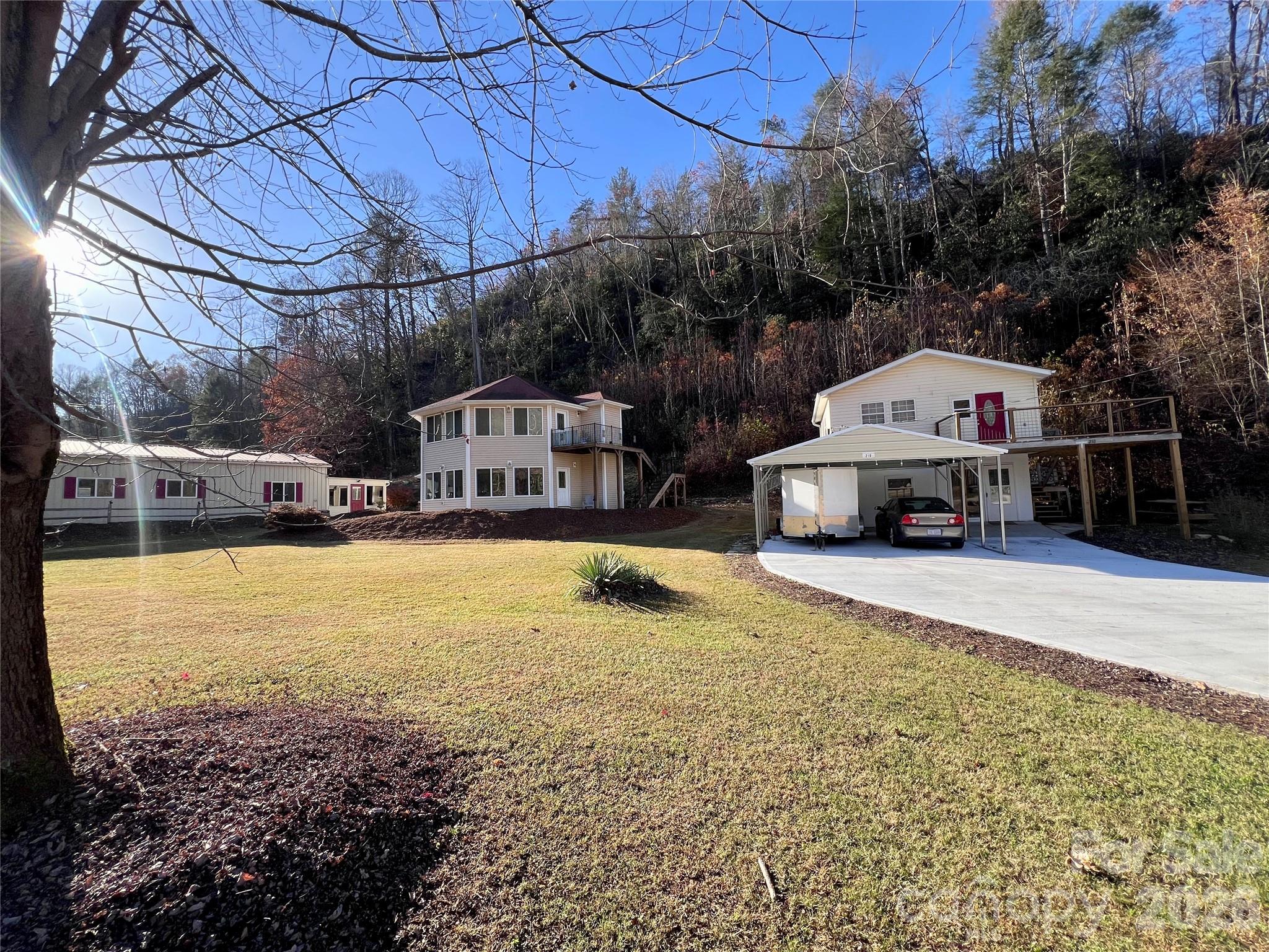 Nestled in the peaceful mountains between Marion and Mount Mitchell, just above Lake Tahoma along scenic Hwy 80 in Marion, NC — famously known as “The Devil’s Whip” — this unique property offers three incredible spaces on one property and wired Spectrum Internet. Renowned for its breathtaking mountain scenery, winding roads, and connection to the Blue Ridge Parkway, Hwy 80 is a destination favorite for motorcycle and sports car enthusiasts seeking one of Western North Carolina’s most iconic drives.
The main residence features comfortable living areas with the relaxing sounds of the nearby creek, creating a serene mountain retreat. A separate guest cottage offers excellent flexibility for an in-law suite, private guest quarters, or potential rental income, with an open kitchen, living and dining area, laundry, plus an upper-level one-bedroom suite and full bath. Enjoy the private deck overlooking the creek and surrounding natural beauty.
Another standout feature is the detached garage and recreation space complete with a living area, kitchen, and full bath — perfect for hobbies, entertaining, guest overflow, or the ultimate man cave and space for cars or motorcycles.. Whether you’re searching for a mountain getaway, flexible multi-generational living, or the perfect home base for exploring the Blue Ridge Mountains, this rare Western North Carolina property offers endless possibilities.
