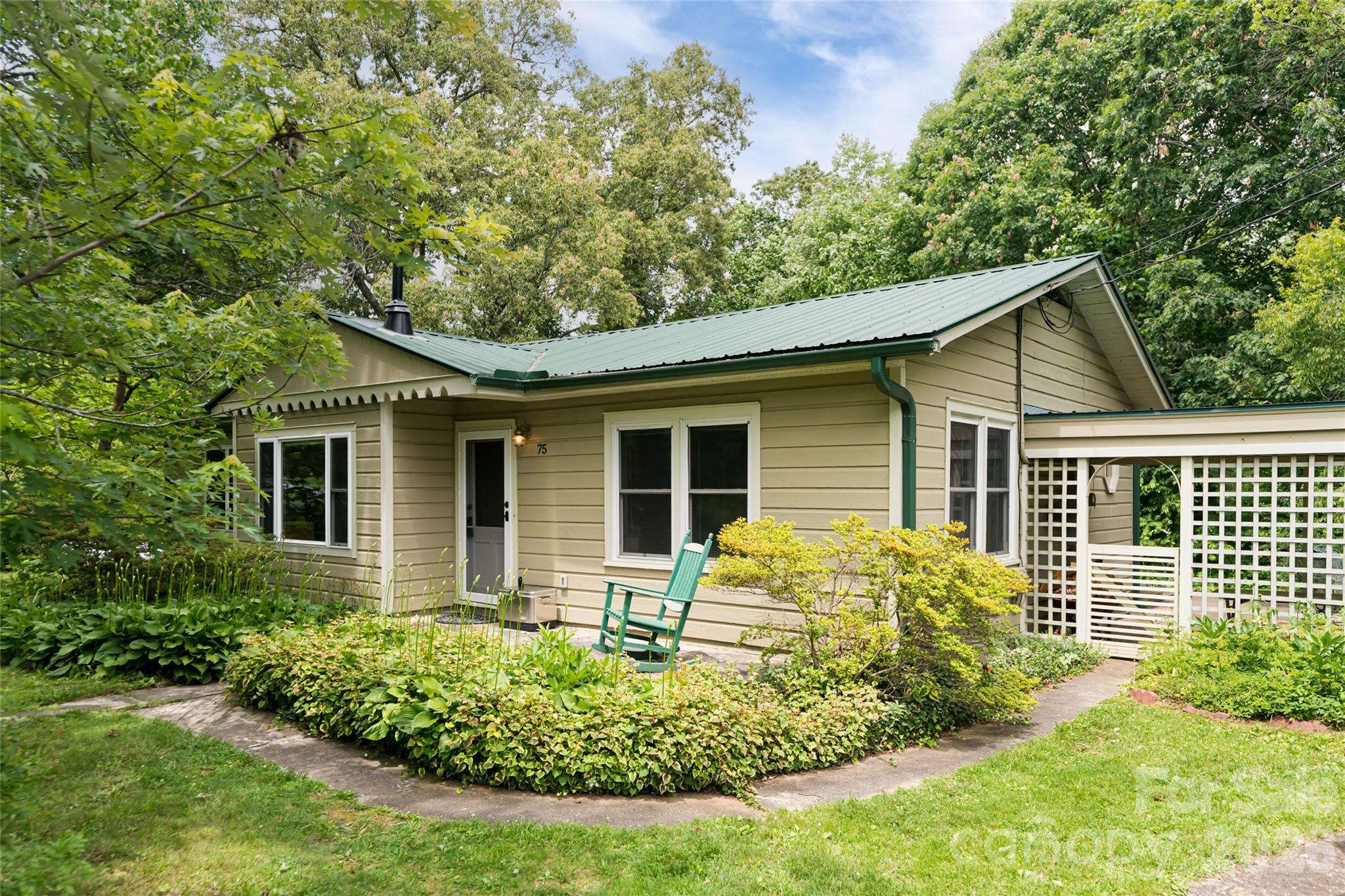 TWO houses on one lot!! 
Main Home 3 bedrooms, 3 full baths, 1200 SF 
PLUS Guest Cottage with 1 bedroom, 1 bath, approx 404 SF

Both Houses have wood floors, lots of natural light, surrounded by nature. 

Main home includes woodstove, screened in porch, jacuzzi tub, two bedrooms have ensuite bathrooms. The third bedroom is perfect for a home office, guest room, or child's bedroom. 

Adorable cottage is currently operating as a successful short term rental inside of the city limits. 

Detached garage with workshop potential. 

Level lot, almost 1/2 acre, park like setting, mature landscaping, quiet neighborhood, abundant wildlife, blueberries, strawberries, figs. 

Less than 10 minutes to downtown, music, art, restaurants, etc. Walking distance to the library, close to Blue Ridge Parkway, hiking trails nearby. 

Bird lovers paradise!