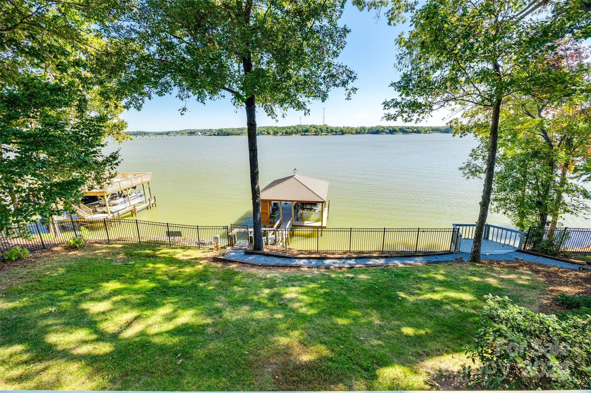 Indulge in the epitome of luxury lakefront living in the exclusive, amenity-rich, 24/7 gated River Hills community. This RARE MAIN CHANNEL home on Lake Wylie offers not just a residence, but resort-style living every day. With 4 bedrooms, 3.5 baths, and two versatile flex spaces, this extraordinary home boasts breathtaking MAIN CHANNEL WATER VIEWS as far as the eye can see. Step outside to your brand-new covered dock, fully outfitted with a bar, storage, & boat lift, or unwind on one of the expansive decks perfectly positioned to soak in the stunning waterfront. Designed with elegance and ease, the home's flowing layout is perfect for intimate gatherings or grand entertaining, with every detail crafted to embrace the beauty of the lake. In the prestigious River Hills Country Club community, enjoy not only one-of-a-kind breathtaking water views, but an enviable lifestyle w. low SC taxes, top-rated schools & convenient access to Charlotte—offering the ultimate lakeside living experience!
