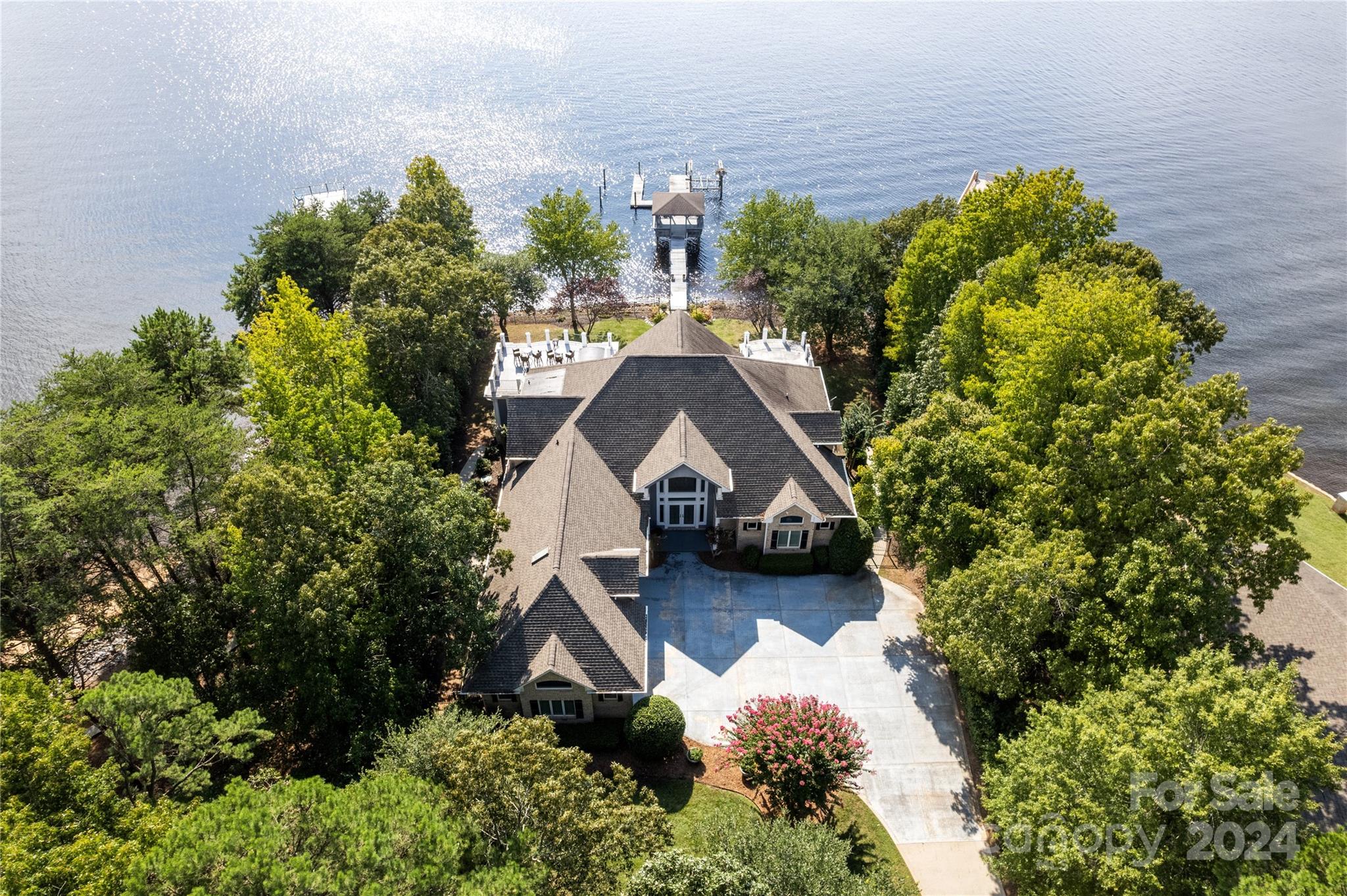 Spectacular Main Channel Sunset Views Over Little Mountain from this Custom Home on Private Point Lot! 4 Bedrooms, 4/2 Baths, All formals, Chef's Kitchen, Theater, Two Offices & lots of storage! As you make your way down the long private driveway, you arrive with gorgeous water views to the full brick majestic home. You are greeted in the entry hall with a two-story long-range view of Lake Norman. Formal dining & living as you move towards the lake. The Chef's Kitchen on your left is open to the breakfast area & generous sunroom which includes a fun cocktail bar. Behind the kitchen is a large pantry & laundry room with half bath. As you walk into the Primary Suite on the main level, beautiful lake views abound from the extended sitting area with fireplace & outdoor covered patio. You will be pleasantly surprised with the large closet & private office flanking the hallway to the primary bath. This is lake living at its finest! SELLER FINANCING AVAILABLE at 5% for qualified buyers!