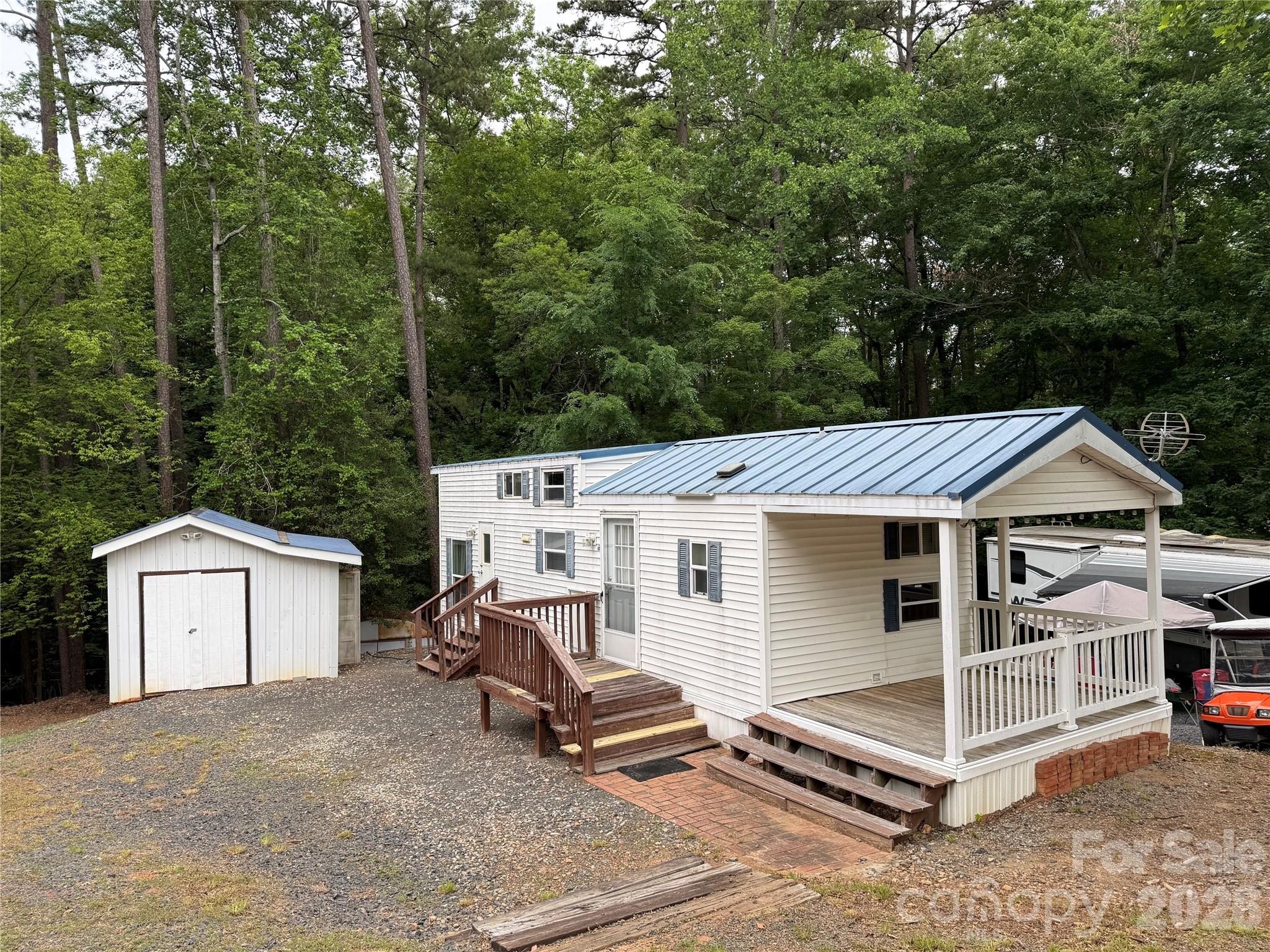 Well this unit is just fun. 2008 Park Model with 2 bedrooms, 2 bathrooms and double lofts. An additional 12' of common area was purchased, making it perfect for the full addition. The lot backs up to woods so there will never be anything behind you. There is a covered front porch for waving at folks and watching the golf carts go by.  Full size appliances to remain. Washer/dryer in out building to remain. Taller ceilings in the living room and dining area. Both bedrooms are of good size. Primary bedroom is 2 steps down and has a queen bed. The other bedroom has a double on bottom and a single on top. Both bathrooms have step in showers.  Close to the heart of the park and the church. This one comes furnished. Come and see if this could be your "Happy Place" here in the park. This park model has 2 entrys/exits. The propane tank to the gas pack HVAC was rented and return to propane company for lack of use in the winter. Seller states heat worked well when they removed the propane tank.

All buyer's must be with a realtor to gain entry to the community.