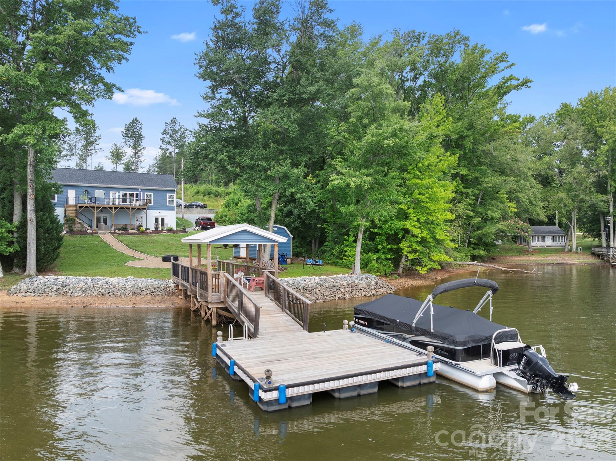 Looking for a High Rock Lake Waterfront home with TWO homes in ONE? We have one up & one down! Use the upper drive or lower drive! With over 3,300 sq. ft. of htd living area, this beautiful waterfront property features separate living on the main level & a finished walkout basement, each with its own full kitchen & laundry closets. The main level offers an open floor plan with 2 bedrooms, a flex room, 2 full baths, spacious living areas, and stunning lake views. The finished basement includes a second primary suite & exceptional flex space ideal for guests, recreation, a home office, gym, or multi-generational living. Enjoy approximately 85 feet of waterfront, a pier, outdoor shower, & an oversized rear deck overlooking High Rock Lake. Whether you're searching for a primary residence, weekend retreat, or vacation home, this property offers flexibility, comfort, and the lakefront lifestyle you've been waiting for. Don't miss this opportunity to own your piece of High Rock Lake paradise!