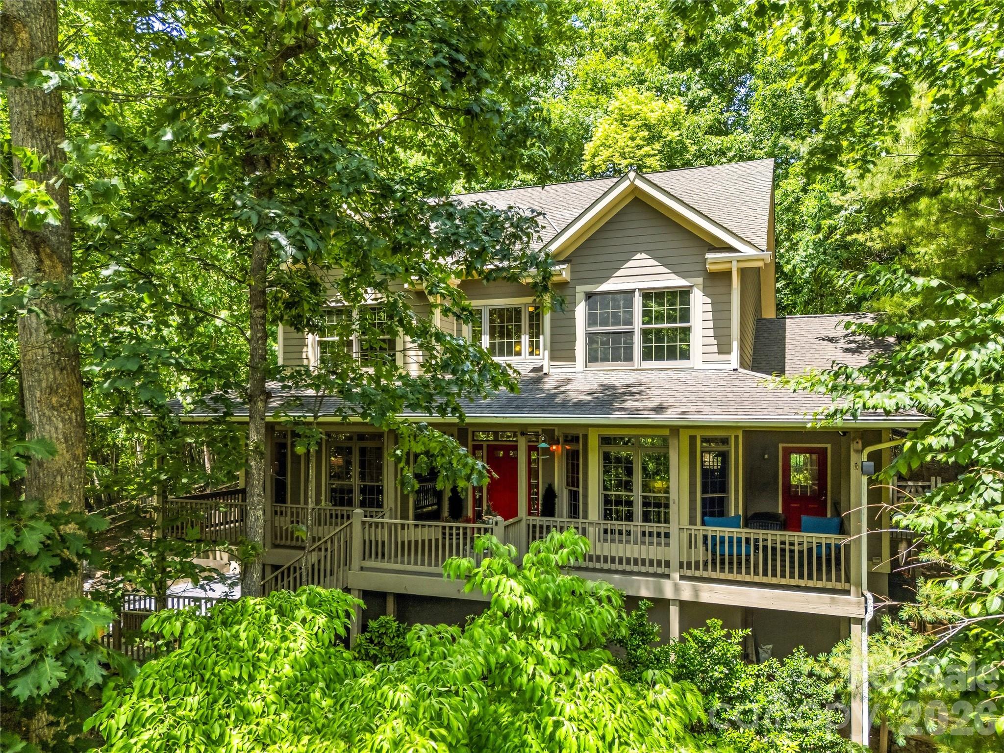 Perched on a hill with heartwarming valley, mountain and woodland views, this retreat seamlessly blends comfort and nature. Step inside to a light-filled, two-story great room featuring a fireplace, walls of windows and a roomy dining area. Perfect for entertaining, this space flows directly to a convenient back deck allowing family and friends to spread outdoors while staying part of the fun. The open floor plan flows effortlessly into a well-equipped kitchen with breakfast bar seating, built-in appliances and nearby pantry. The main-level primary suite is incredibly spacious and a nearby reading room might easily doubles as a home-office. The versatile walk-out basement provides excellent storage for a plethora of outdoor gear, plus finished space ideal for a gym, studio, or family room. Enjoy the community pool, tennis/pickleball courts, and direct access to Pisgah National Forest trails or take a short drive to shopping, dining, and entertainment just minutes away in South Asheville.