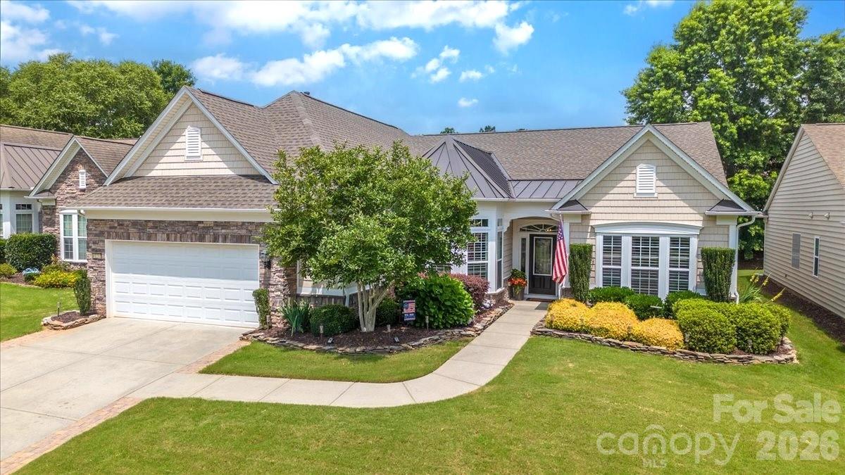 Experience premier active adult living in this immaculate, turnkey home on a gently curved tree-lined street in Sun City Carolina Lakes!  An expanded driveway, mature landscaping, and stacked stone garden beds maximize this homes curb appeal.  Major 2025 updates include a newly installed roof and HVAC system.
Step inside the inviting, light filled foyer which sets the tone for the rest of the home. Flanking the entry, a private home office features elegant glass French doors and large windows overlooking the front garden, where custom shutters allow the morning sun to beautifully filter in.
The central gathering space of the home is a modernized kitchen, showcasing white perimeter cabinetry enhanced with trim at both the top and bottom for a seamless, custom-built look. The space features a custom accent island and a sleek, integrated range hood that vents directly to the outside. Cooking is a delight with the professional gas cooktop conversion and premium stainless-steel appliances, while thoughtful pull-out shelves make meal preparation and organization effortless. Flooded with light, the kitchen transitions beautifully into a bright eat-in area at the front, while flowing into a spacious great room and dining area defined by a fresh neutral palette, updated lighting, and engineered hardwood flooring.
Unwind in the primary retreat, complete with a tray ceiling, custom window shutters, and a spa-like en-suite bath with an oversized dual vanity, LVP flooring, and a masterfully designed walk-in closet with built-ins. A completely separate guest wing offers optimal privacy, featuring two spacious bedrooms each with walk-in closets. These rooms are connected by a Jack-and-Jill bath with dual vanities and updated LVP flooring. For ultimate versatility, one guest room is outfitted with LVP flooring, making it the perfect 
art studio, craft room, or third bedroom.
The highlight of the property is the beautifully finished drywalled sunroom, featuring modern lighting above the ceiling trim for a soft, upscale ambiance. Expansive windows with custom blinds flood the space with natural light, bringing the outdoors inside. With its own mini-split climate control system, the room provides year-round comfort and panoramic views of the professionally landscaped backyard. It is a true sanctuary for enjoying morning coffee, reading a good book, or unwinding to the sounds of the garden.
Step outside from here onto an expansive paver patio, an outdoor oasis beautifully framed by half-walls, crisp paver block edging, vibrant roses, and mature crepe myrtles. Equipped with a remote-controlled awning, this patio provides the ultimate setting for shaded outdoor dining and entertaining.
Enjoy resort living just minutes from the Charlotte metro area. As a resident of this vibrant Del Webb community, you will enjoy world-class amenities just a short golf-cart ride away. Take advantage of two multi-million dollar clubhouses, indoor and outdoor swimming pools, tennis, bocce and pickleball courts, softball field, fitness center, wood working shop, miles of scenic walking trails, an 18-hole public golf course woven right through and much more!