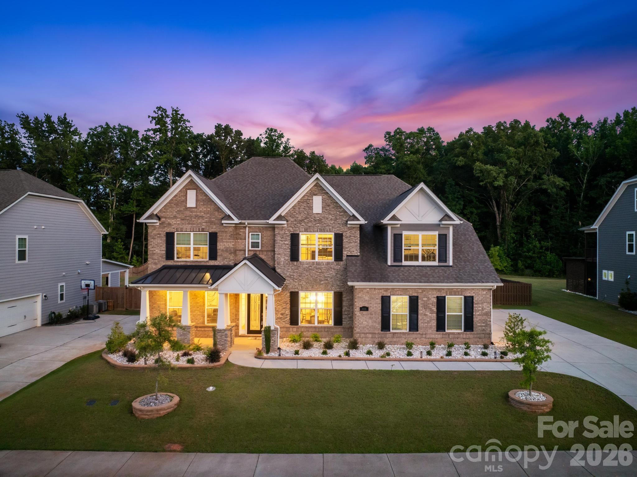 Nestled on a generous 0.44-acre homesite in the highly sought-after Harlow's Crossing, this exceptional five-bedroom, five-and-a-half-bath residence showcases the perfect balance of timeless craftsmanship, thoughtful design, and modern convenience. Built in 2021, every space reflects careful attention to detail, from extensive crown molding, hardwood flooring, and custom millwork to elegant coffered and tray ceilings that add warmth, character, and architectural interest throughout.

Designed to bring people together while still offering spaces to retreat, the heart of the home is an expansive great room anchored by a striking stone fireplace that flows effortlessly into a beautifully appointed kitchen. An oversized island creates the perfect gathering space, complemented by 42-inch cabinetry, quartz countertops, a walk-in pantry, a dedicated office nook, and a thoughtfully designed drop zone that keeps everyday living organized. The formal dining room and private executive office feature tray ceilings, while a main-level bedroom with a full en-suite bath offers exceptional flexibility for guests, extended stays, or those seeking the convenience of a first-floor suite.

Upstairs, the spacious primary suite provides a peaceful retreat with a tray ceiling, intricate crown molding, a sitting area, two walk-in closets, and French doors leading into a beautifully designed ensuite featuring dual vanities, a soaking tub, a separate walk-in shower, and a private water closet. Each secondary bedroom enjoys direct access to a full bathroom, while the generous bonus room and open loft create flexible spaces for recreation, media, fitness, hobbies, or additional workspace.

Outdoor living is just as inviting. The screened sunroom extends the living space and overlooks a private, fenced backyard where an expansive paver patio and built-in fire pit create an ideal setting for entertaining or simply unwinding at the end of the day. The nearly half-acre homesite offers plenty of room to enjoy the outdoors while maintaining a sense of privacy.

Additional highlights include two HVAC systems, LED lighting throughout, abundant storage, built-in features, an EV charger, and a professionally finished garage with epoxy floors that add both durability and a polished finish.

Ideally located just minutes from Waverly, Rea Farms, Weddington Swim & Racquet Club, the YMCA, boutique shopping, dining, and everyday conveniences, with convenient access to I-485, Providence Road, and US-74, this home offers an exceptional combination of quality craftsmanship, functional design, and one of Union County's most desirable locations.