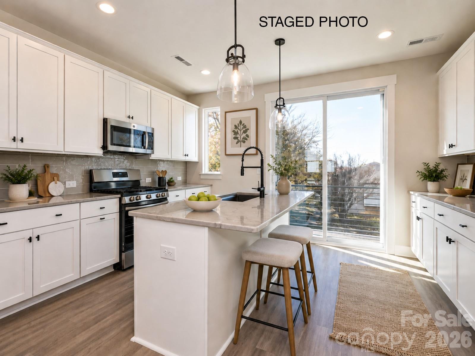 Have it all with this Camp North End-area townhome. 4 floors include a 1st floor flex room w/ powder, terrace off the kitchen w/ seasonal city skyline views, & a nice sized 4th floor rooftop terrace & bedroom/rec room w/ powder. Abundant space for entertaining, guests, or home office. Also included is a 1-car garage & driveway.  Kitchen features 42" cabs, matte black hardware, trash pullout, large undermount stainless sink, quartz counters, and GE stainless steel appliances with a gas range. It leads to the open dining/living area. 3rd floor has a laundry closet and a hall bath. Full baths include matte black hardware, quartz counters, and tiled floors, with a tiled shower in the Premier Bath with semi-frameless glass. LVP is throughout the 1st & 2nd floor plus 3rd floor hall, with tile in full and half baths, and oak treads on all stairs. 9' ceilings throughout. Uptown Charlotte is just minutes away!