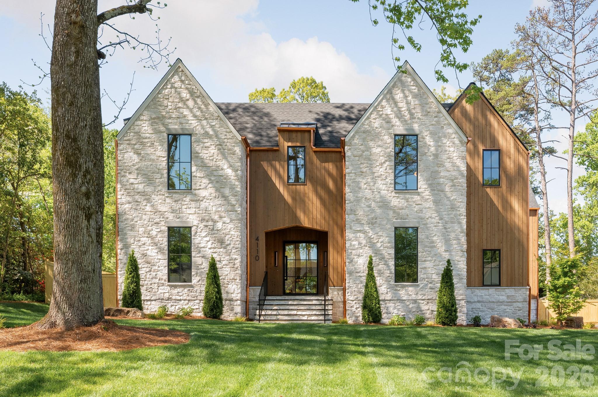 Perfectly positioned in the heart of Cotswold, 4110 Melchor is a masterfully crafted Scandinavian Modern new construction by Pike Properties — a home that redefines luxury living in one of Charlotte's most coveted neighborhoods. With just under 6,000 square feet of thoughtfully designed space, every detail has been considered to deliver a living experience that is both elevated and effortlessly livable. The architectural language is clean, intentional, and unmistakably Scandinavian — defined by natural materials, warm minimalism, and a seamless dialogue between interior and exterior. Soaring ceilings, walls of glass, and abundant natural light create an atmosphere that feels expansive yet intimately comfortable. Custom cabinetry flows throughout the entire home, a thread of craftsmanship that ties every room together with quiet sophistication. At the heart of the main level is a showpiece kitchen that is as functional as it is stunning — and behind it, a full scullery kitchen running the entire length of the main kitchen, discreetly housing a beverage refrigerator, refrigerator pull-out drawers, 2nd dishwasher, and everything needed to keep the main stage pristine while entertaining. Whether hosting an intimate dinner or a grand celebration, this kitchen pairing is a chef's and entertainer's dream realized. Step outside and discover an expansive back porch that lives like a true extension of the home. Three remote-operated phantom
screens allow you to open or enclose the space at will, while a fully appointed summer kitchen, dedicated dining area, and outdoor living room with fireplace create an al fresco environment worthy of the interior it mirrors. Rain or shine, the outdoor living here is unmatched. Upstairs, each bedroom enjoys the luxury of a large private closet and its own en-suite bathroom — a thoughtful design that offers every member of the household their own retreat. A dedicated powder bath serves the bonus room, ensuring convenience without compromise. Tucked into its own private wing, the primary suite is in a category of its own — anchored by soaring 12-foot vaulted ceilings, a massive walk-in closet, and a spa-inspired bathroom that transforms the daily routine into a restorative experience. Even the details you didn't know you needed are here — including a dedicated dog wash station that speaks to the home's rare combination of luxury and genuine livability. The three-car garage completes a package designed for the way people actually live. Located minutes from premier dining, boutique shopping, top-rated schools, and the energy of SouthPark, this custom home offers the quiet sophistication of one of Charlotte's most desirable streets — and a standard of living that is simply without equal.