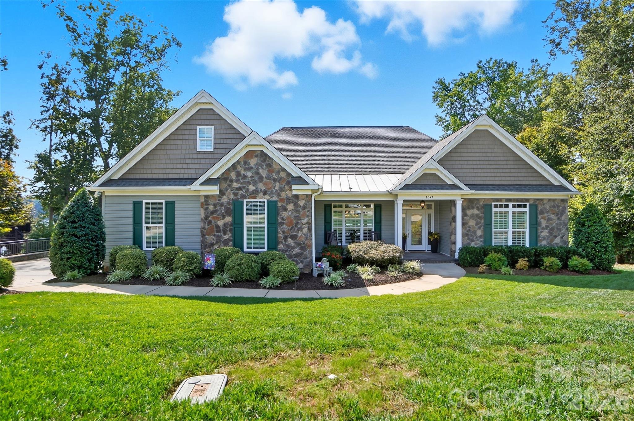 Enjoy breathtaking Lake Wylie views every day from this fabulous 4-bedroom waterfront home, thoughtfully designed for both everyday comfort and unforgettable entertaining. Nestled in a beautifully landscaped setting, this dream home offers a seamless blend of elegance, function, and outdoor enjoyment. Step inside to a bright and airy open floor plan filled with natural light, featuring gorgeous flooring, arched doorways, tray ceilings, and custom finishes throughout. The dedicated home office with French doors provides privacy for work or study, while the formal dining room—with its elegant tray ceiling—is perfect for hosting everything from casual dinners to festive holiday gatherings. The lake-facing great room boasts a cozy fireplace and expansive windows that frame the stunning water views, flowing effortlessly into a gourmet kitchen complete with stainless steel appliances, granite countertops, a center island, pantry, and charming breakfast area. Start your mornings or unwind at the end of the day in the sunroom, where panoramic views of the lake set the scene for relaxation, reading, or coffee with friends. Retreat to the main-level primary suite, a true sanctuary featuring tray ceilings, a spacious sitting area, walk-in closet, and a luxurious spa-like bath. Two additional bedrooms complete the main floor. Downstairs, the fully finished lower level offers even more space to entertain and unwind, with a huge rec room, a wet bar, a guest bedroom with full bath, and generous storage. Outdoor living is unparalleled with a covered patio, two decks, and a lakeside firepit—perfect for evening gatherings under the stars. Enjoy boating, fishing, and water sports from your private covered dock with boat lift. Located in the sought-after Belmont area, you’ll love the small-town charm combined with the convenience of being just minutes from uptown Charlotte.