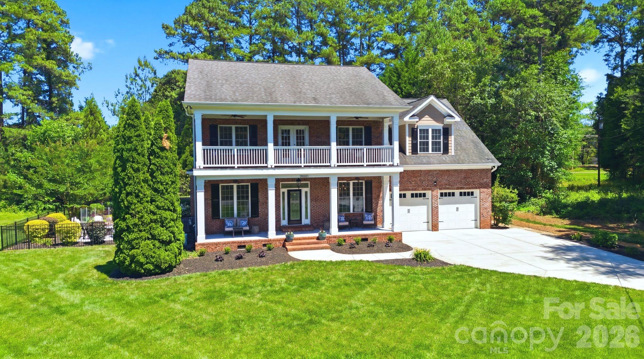 Welcome to this beautifully crafted custom home nestled on a quiet dead-end street just across from Lake Norman waterfront homes. Situated on a .40-acre lot, this exceptional residence offers 4 bedrooms, 3.5 bathrooms, and 4,006 square feet of thoughtfully designed living space. Combining privacy, charm, water views, and ample room to live and entertain, this property is a rare opportunity for buyers seeking space, tranquility, and convenience near Lake Norman.

An inviting double front porch creates a warm first impression, while the upper porch provides relaxing views of Lake Norman. Inside, the thoughtfully designed floor plan features a main-level primary suite, dedicated office, formal dining room, and an open-concept living area centered around a stunning stone fireplace. An enclosed porch extends the living space and overlooks the private, tree-lined backyard.

Upstairs, three spacious bedrooms each feature an adjoining bathroom, along with a versatile flex space and an oversized bonus room ideal for a media room, recreation room, home office, or hobby space.

Step outside to a backyard retreat designed for relaxation, featuring a new composite deck, refreshed landscaping, winding pathways, garden spaces, a fire pit gathering area, water views, and a storage shed for tools and outdoor equipment.

Located just minutes from Birkdale Village, shopping, dining, and everyday conveniences, this unique property offers the perfect blend of privacy, space, and sought-after lake-area living.