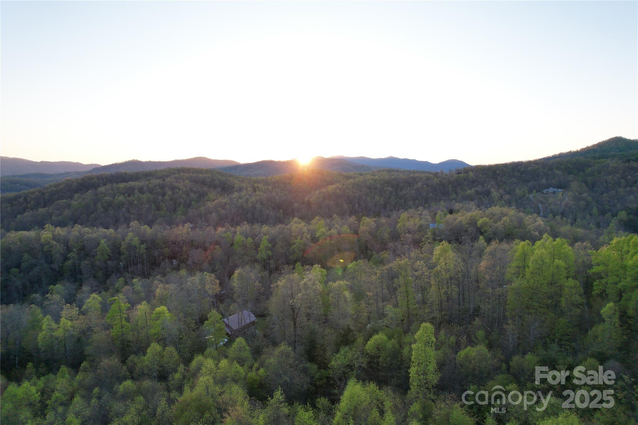 Exceptional opportunity to own 18.26 acres on Old Fort Road in Buncombe County, just 7.5 miles from downtown Black Mountain and 20 miles from Asheville. This property features rolling terrain, long-range mountain views, wooded privacy, and paved state-maintained road frontage. Positioned at the entrance of the planned Bel Air Asheville community, a resort development including proposed glamping, spa, and residential amenities. The land holds unique strategic value for investors and developers. Zoned Open Use, it offers flexibility for residential, private estate, subdivision, or potential commercial or mixed-use development that complements the resort. Utilities are readily available with two power access points and recently upgraded fiber-optic cable on each side of the property. With its location, infrastructure, and proximity to Bel Air Asheville, this acreage represents a rare opportunity to invest in the future of Black Mountain’s growth corridor.