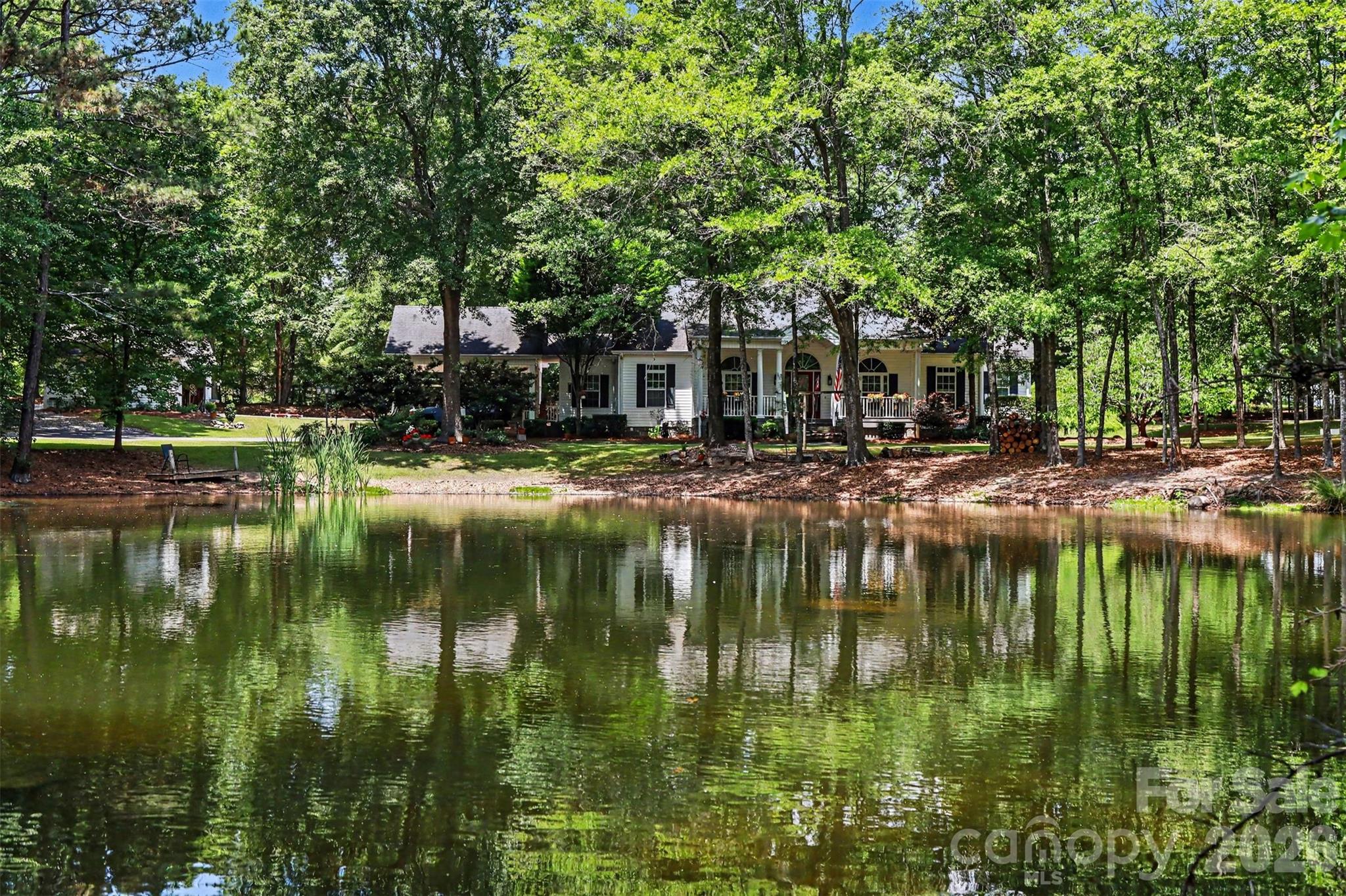 Stunning custom home on 5 private acres with a picturesque pond, mature trees, and peaceful scenery. Inside, enjoy soaring ceilings, hardwood floors, a stacked stone fireplace, and an open floorplan with abundant natural light. The kitchen features granite, custom cabinetry, and stainless appliances, while large windows and glass doors frame beautiful property views.

The true highlight is the custom-made 793 sq ft kennel building with 30 runs—professionally designed for breeding, boarding and training. It includes multiple indoor/outdoor runs, a grooming and bathing area, laundry space, a kitchen setup, a full bath, and climate control throughout. No business is included, only the Class A facility. No commercial boarding is allowed. Perfect for private boarding, breeding, show dogs, training etc. 

A large pole barn offers covered storage for RVs with power supply and dump station, equipment storage, or workshop use. A separate tiny home with a studio room, kitchen, bath, septic system, and power is perfect for guests, or caretaker quarters. Ideal for a private estate or turnkey canine training operation.