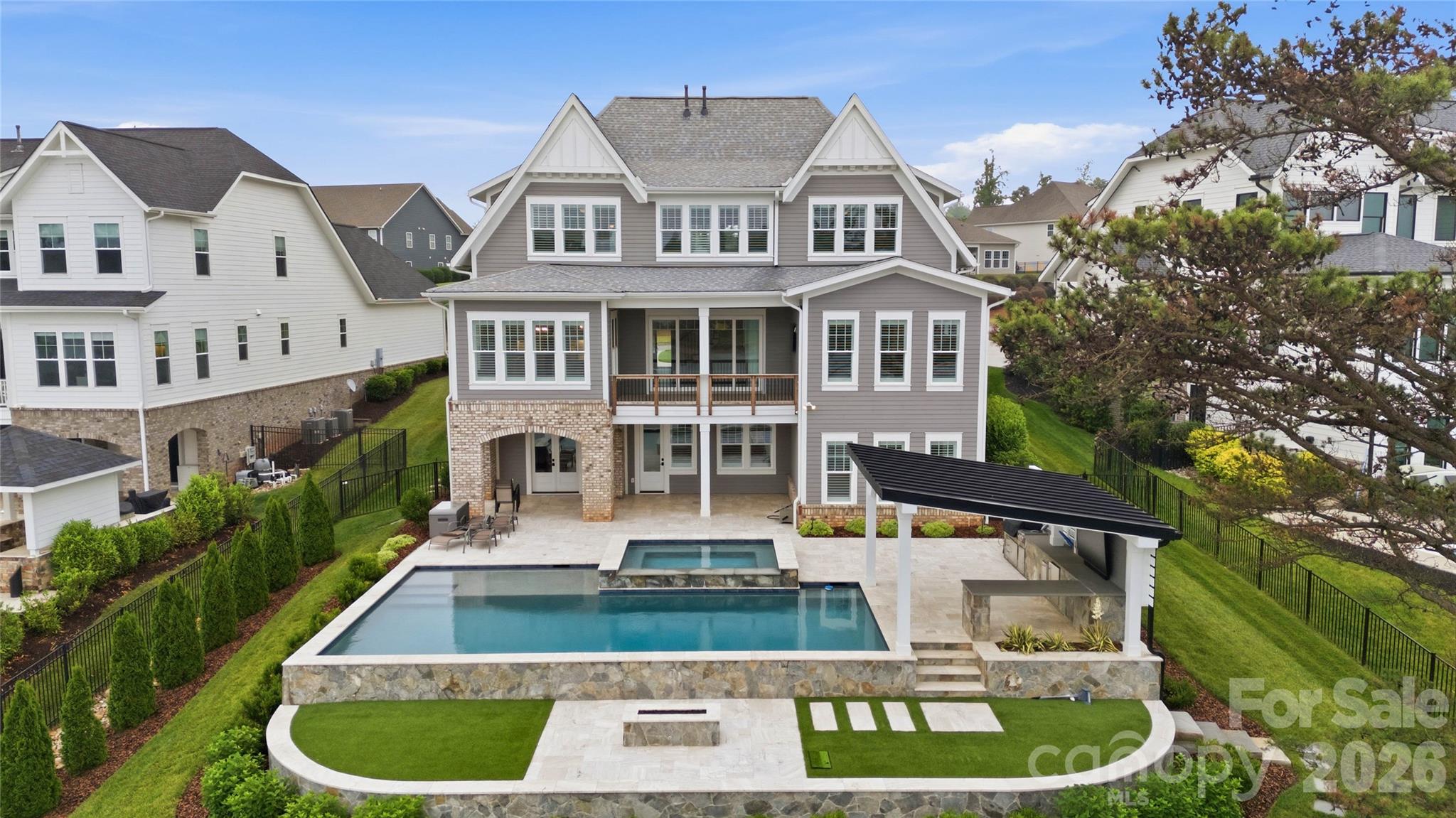 Welcome to 115 Little Indian Loop — a custom-designed waterfront estate in the highly sought-after Lakewalk community. Completed in 2021 and never occupied full time, this exceptional residence presents a rare opportunity to own what is essentially a brand-new luxury home with a three car garage and some of the finest open-water views on the lake.
Thoughtfully crafted with high-end finishes and elevated design throughout, the home offers an expansive open-concept floor plan ideal for both everyday living and sophisticated entertaining. The chef’s kitchen is a true centerpiece, featuring quartz countertops, a farmhouse sink, a 5-burner gas cooktop, double ovens, premium stainless steel appliances, and an oversized walk-in pantry.
The lakefront primary suite is a private retreat, showcasing breathtaking water views and a spa-inspired bath complete with dual vanities, quartz surfaces, a spacious walk-in shower, and a custom-designed closet with extensive built-ins. Upstairs, you’ll find three additional bedrooms, two full baths, and a versatile bonus room, providing exceptional space and flexibility for family and guests.
What truly sets this home apart is the fully finished walkout lower level and the extraordinary outdoor living experience. The lower level features a spacious family room with direct access to the backyard, along with an additional guest bedroom and full bath.
Designed for resort-style living, the backyard is nothing short of spectacular. An expansive travertine patio surrounds a custom heated freshwater pool, oversized spa, and gas firepit — creating the perfect setting for both quiet mornings and unforgettable evenings. The outdoor kitchen offers seamless functionality for entertaining, whether hosting intimate dinners or large gatherings.
A gentle walk leads to your private boat dock, where stunning long-range water views and the natural beauty of the lake create an unparalleled waterfront experience.