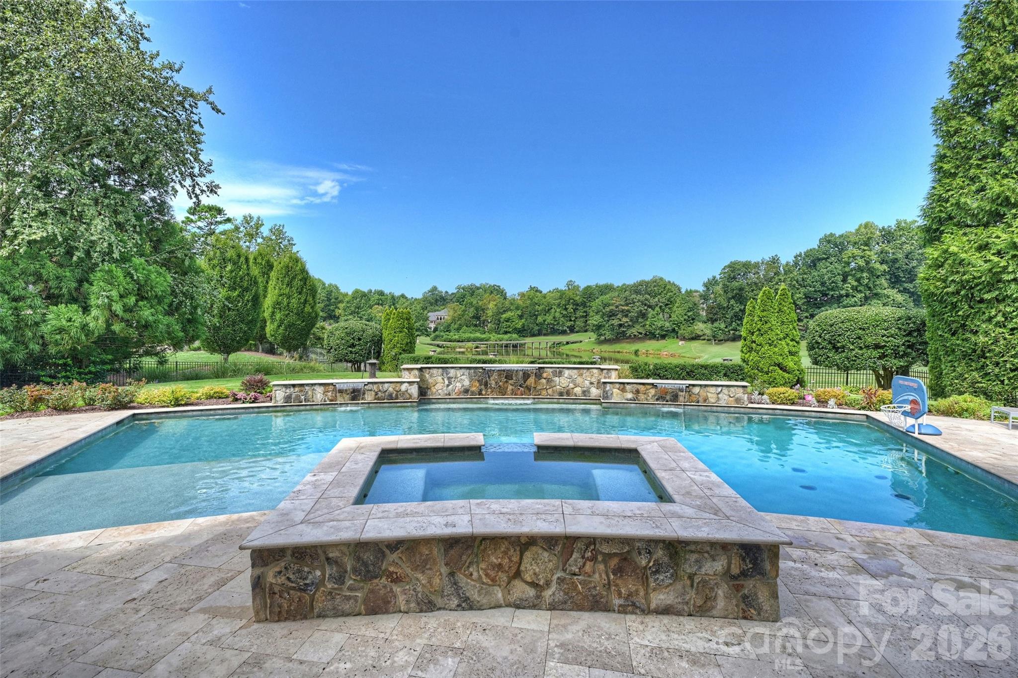You will be the envy of your friends when they visit your own private resort!

It’s probably the BEST view in South Charlotte! You will be drawn to the spectacular views of the signature 13th hole (BCC) from almost every room in the home as well as from the Stunning 48 ft Pool (built in '19.) 

Designed by Christopher Phelps and masterfully built by Simonini Builders, it exudes true modern elegance  in a thoughtfully curated living space. Walls of soaring windows frame the breathtaking views of the pond and wooden bridge. Truly open floor plan, curved walls, & sweeping custom staircase. Gated estate with gas lanterns, paver drive, NEW roof in 2023 & beautiful landscaping.

Imagine yourself in this updated kitchen ('23) w/Taj Mahal quartzite counters, Sub-Zero Fridge ('20), new lighting, 2 dishwasher's...over 8k sq ft of Hardwoods. Primary Bedroom AND a guest suite on opposite sides of the main floor for private multi generational living! Stunning study w/soaring windows is adjacent to Primary bedroom. Also check out the specially designed dining room coffered ceiling, dropzone with built-ins and an amazing laundry room!

Upstairs, Secondary bedrooms are spacious w/ensuite baths, and tons of storage. Up a staircase is a flex room-office, playroom or even a bedroom-also with views!!! 

The fully finished lower level with 11'+ ceilings is designed for exceptional entertaining and relaxation, complete with a bar, wine cellar, theater room, fireplace, rec area, home gym,  second guest suite, and cabana bath with steam shower—creating a true resort-style experience at home.  There is even a perfect spot to add a golf simulator.

Private outdoor living is equally impressive, highlighted by the stunning 48-foot resort-style pool built in 2019, surrounded by lush landscaping and designed to capture the spectacular setting year-round. Car enthusiasts will appreciate the motor court and garages (one w/lift) accommodating up to 4 cars.

Additional recent improvements include a new roof installed in 2023, ensuring both style and peace of mind in one of Ballantyne Country Club’s most remarkable luxury properties.

Showings begin on Thursday.