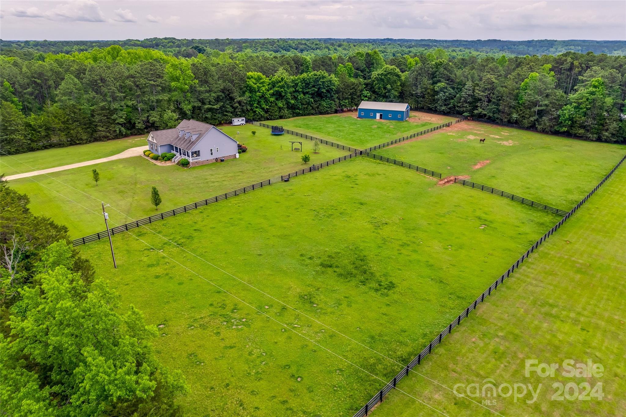 Experience the pinnacle of country living in this stunning 3-bedroom, 3-bathroom home on 5 serene acres. The charming front porch offers a tranquil spot to enjoy the peaceful surroundings. Inside, natural light floods the spacious main living areas with beautiful hardwood floors. The kitchen features granite countertops, a breakfast bar, and stainless-steel appliances, seamlessly flowing into a cozy dining area. Upstairs, a versatile bonus room with a full bath and closet can serve as a 4th bedroom. Outside, the property boasts an expansive 36x60 barn equipped with water, electricity, a feed room (6x12), six 12x12 stalls, and a 12x20 tack room, all designed to capture gentle breezes. Three separate pastures are perfect for horse enthusiasts, offering plenty of space for riding. There's also ample room to add a pool, providing even more options for outdoor enjoyment. This property truly offers the best of country living with modern comforts.