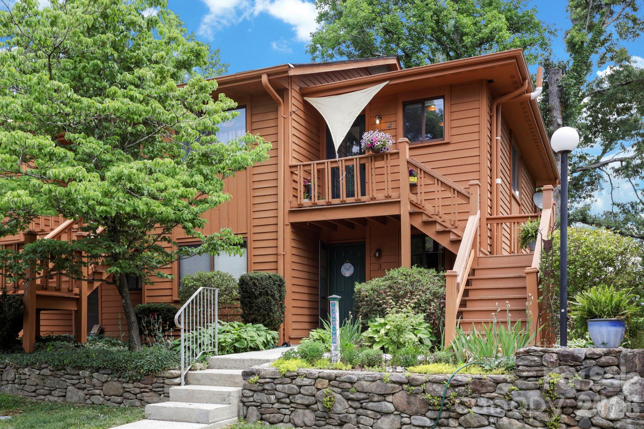 Welcome to this upper-level, two-bedroom, one-full-bath, one-half-bath condominium offering the perfect blend of privacy, personality and low-maintenance living. Positioned at the quiet end of the community, one of the most coveted locations in the development, the home captures distant year-round mountain views from the dining area and overlooks beautifully maintained flower gardens. Inside, the residence has been thoughtfully updated with bold design choices, including a deep navy accent wall and light engineered-wood-style flooring. Sliding glass doors open from the living area onto a private deck, an ideal spot for morning coffee surrounded by a mature tree canopy. The kitchen features white cabinetry and pendant lighting, while the dining area is brightened by a statement chandelier. Recent mechanical upgrades include a new roof, gutters, an HVAC and a water heater, a few years young, which provides genuine peace of mind, and HOA dues are paid through December 2026. All of this sits just minutes from Downtown Hendersonville, the Ecusta Trail, Historic Flat Rock, Flat Rock Playhouse, the Carl Sandburg Home, Pardee Hospital and AdventHealth, with Downtown Asheville only 30 minutes away. A rare opportunity to own a distinctive, move-in-ready home with character and convenience in equal measure.