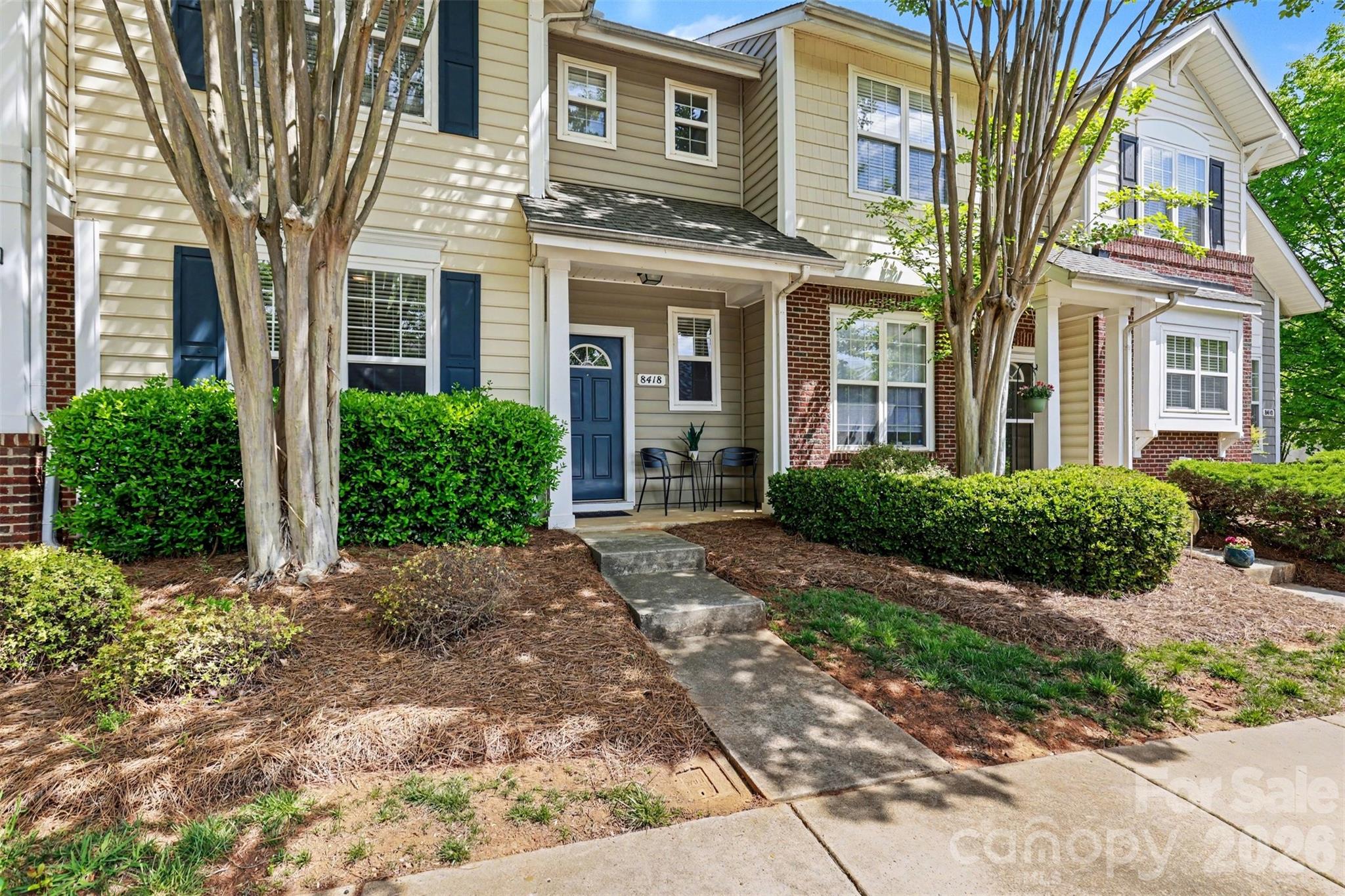 Cozy 3-bedroom, 2.5-bath two-story townhouse with two assigned parking spaces located directly in front of the home. A covered front porch leads into the foyer, where a flexible front room with newly added French doors creates a perfect private office or additional living space. The main level opens into a spacious layout featuring a kitchen with curved island, stainless steel appliances, and neutral granite countertops overlooking a breakfast nook and large family room with fireplace. Sliding glass doors lead to a rear concrete patio with attached storage utility room. Upstairs includes all three bedrooms plus a conveniently located laundry area sized for full-size washer and dryer. The primary suite features a tray ceiling, walk-in closet, and private bath, while the secondary bedrooms share a full hall bath. Community amenities include a pool. Conveniently located near the University area with easy access to hospitals, shopping, dining, and major highways including I-77, I-85, and I-485 for a reasonable commute to Uptown Charlotte.