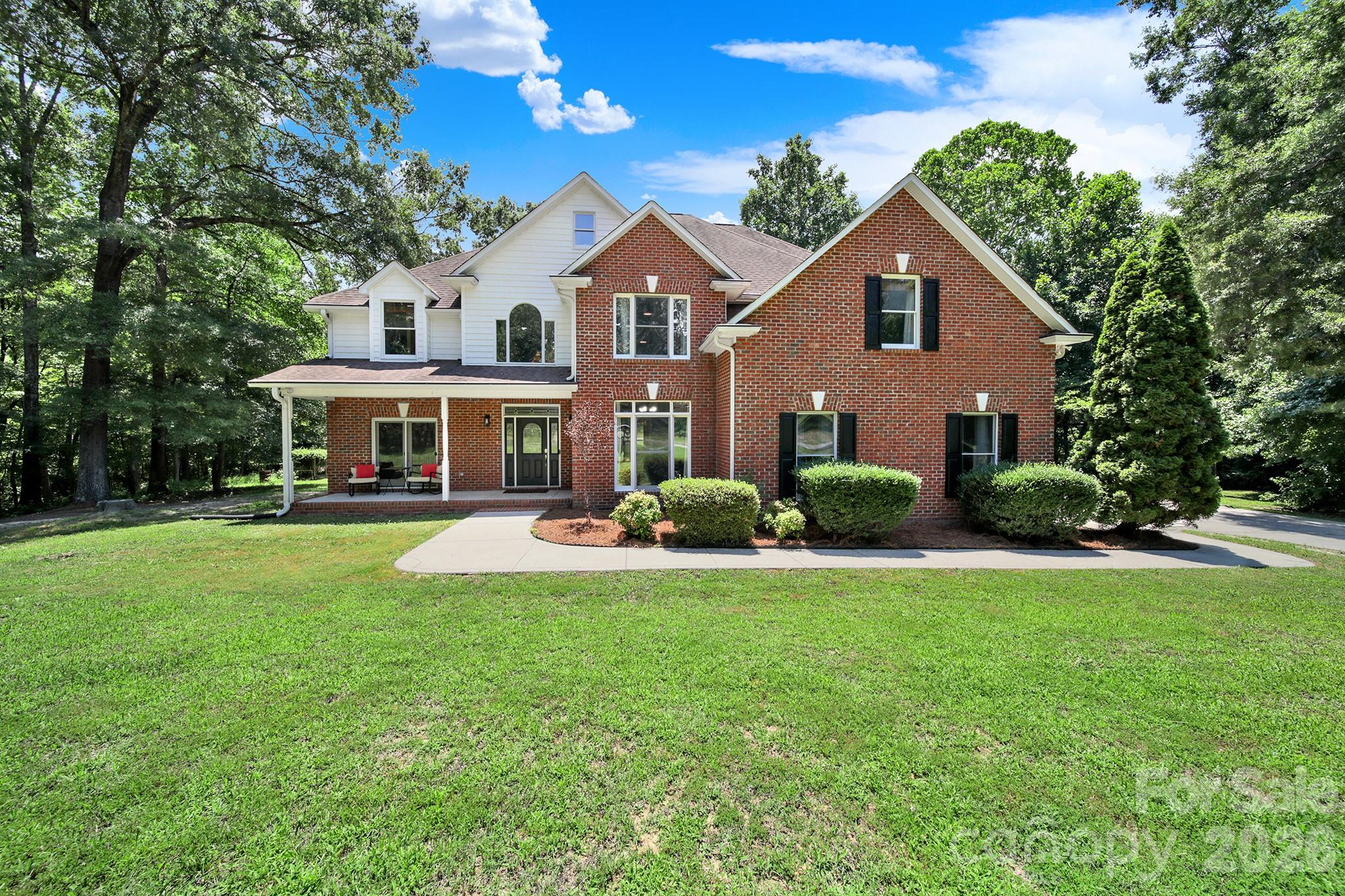 Tranquility at its Best! Nestled on 3.18 private acres at the end of a quiet road, this beautiful 6BR/4.5BA home offers the perfect blend of space, comfort, and privacy. A dramatic two-story foyer welcomes you into an open, light-filled floor plan featuring a formal dining room, spacious family room with wet bar, and a well appointed kitchen with new appliances and a sunny breakfast area. Two main-level bedrooms offer flexibility for guests, a home office, or multi-generational living. Step outside to the expansive deck and gazebo overlooking the large backyard and wooded surroundings—perfect for entertaining or relaxing. A chicken coop adds charm and the opportunity to enjoy your own free-range eggs. Upstairs, the spacious primary suite features a cozy sitting area with a gas fireplace, a large ensuite bath, and dual walk-in closets. Three additional bedrooms, two full baths, and an oversized bonus room provide plenty of room for family, hobbies, or recreation. Enjoy peaceful country living with the convenience of close by award winning Clover schools, restaurants and shopping. This is a thoughtfully designed home that's ideal for everyday living and entertaining.