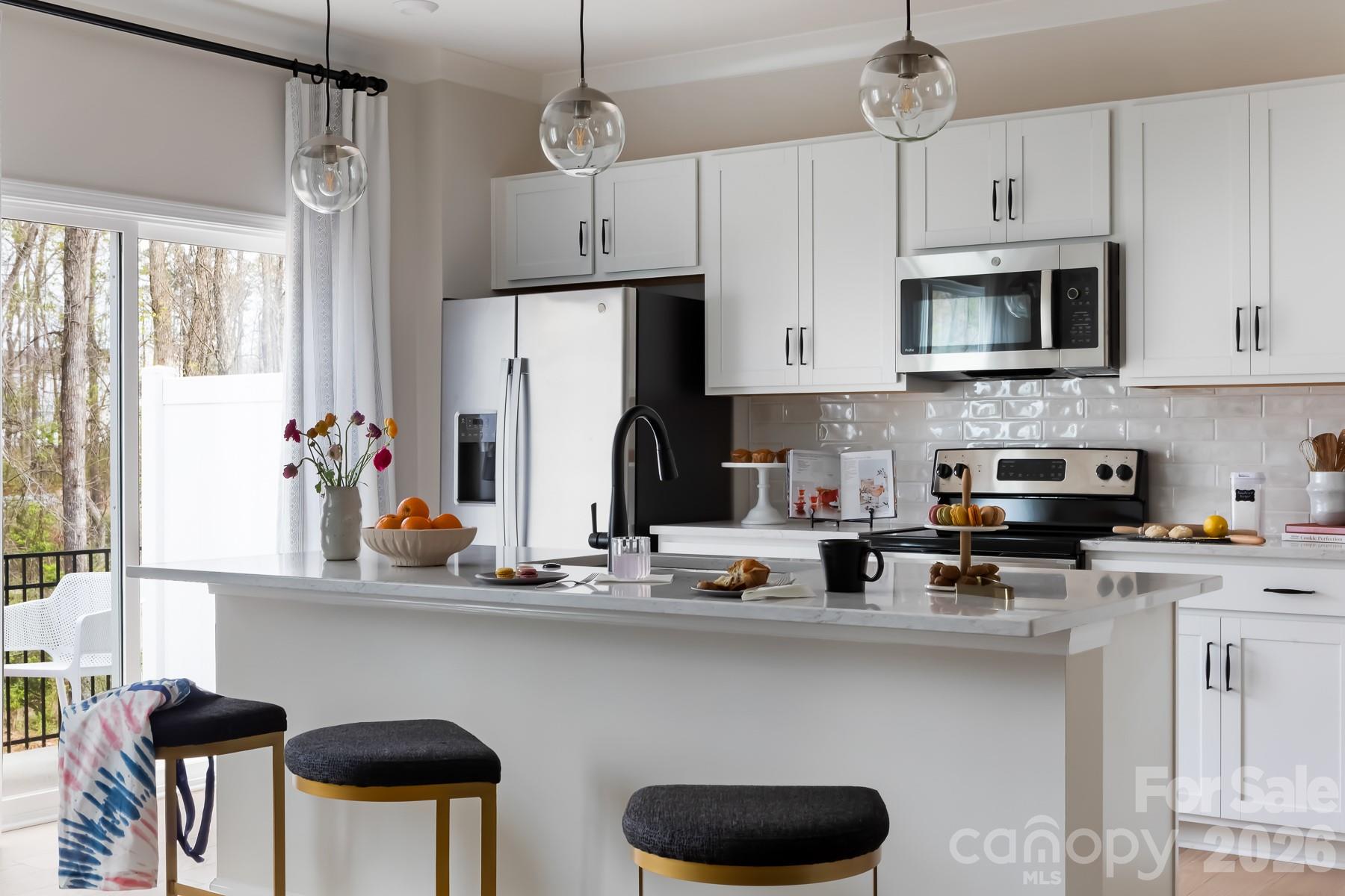 Tucked into Fifteen 15 Cannon, this two-story Anson townhome delivers the low-maintenance lifestyle you've been looking for, with landscaping and yard care handled, tree-lined paths right outside, and the city's best dining, arts, and entertainment just moments away. Inside, soaring ceilings and an open-concept first floor set the tone, anchored by a chef-ready kitchen featuring white cabinetry, Natural Stone Slab Perla Tao Granite countertops, a large single-bowl stainless steel sink, and a generous walk-in pantry. Step outside to your extended outdoor living space and take in the wooded views that give this home a sense of privacy you rarely find this close to the city. Upstairs, a flexible loft adapts to whatever you need, whether that's a home office, library, or extra lounge space, while two bedrooms each have their own full bath. The primary suite faces the wooded backdrop for a quiet retreat feel, and the en-suite bathroom brings spa-like touches with a dual vanity, tiled walk-in shower, and a walk-in closet. Smart home features including wi-fi light switches, a garage door opener, Ring doorbell, and smart thermostat come standard, so you're move-in ready from day one.