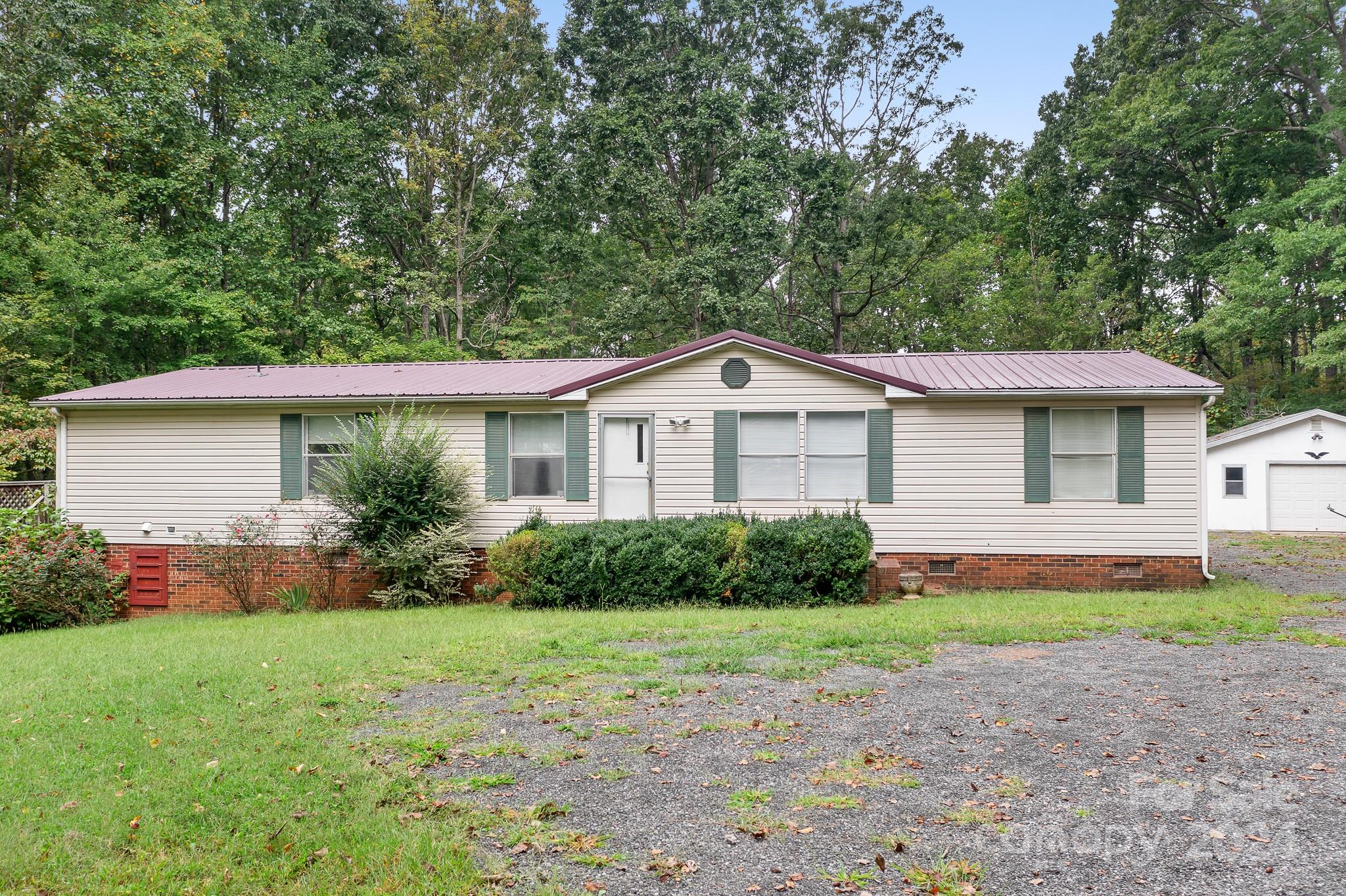 This charming 3-bedroom, 2-bath home is situated on over 4 acres of serene, private wooded land, perfect for nature lovers and wildlife enthusiasts. The home features a spacious living room and a cozy den with a fireplace, providing ample space for relaxation or entertaining. The split bedroom plan ensures privacy, with the master suite separate from the other bedrooms. The 4.22 acres provide plenty of room for a mini farm, garden or outdoor entertaining space. A detached 24x28 garage/workshop, complete with an air compressor, offers space for all your projects, and a storage shed provides convenient room for lawn equipment. Put your personal touches on this home and enjoy peaceful country living.