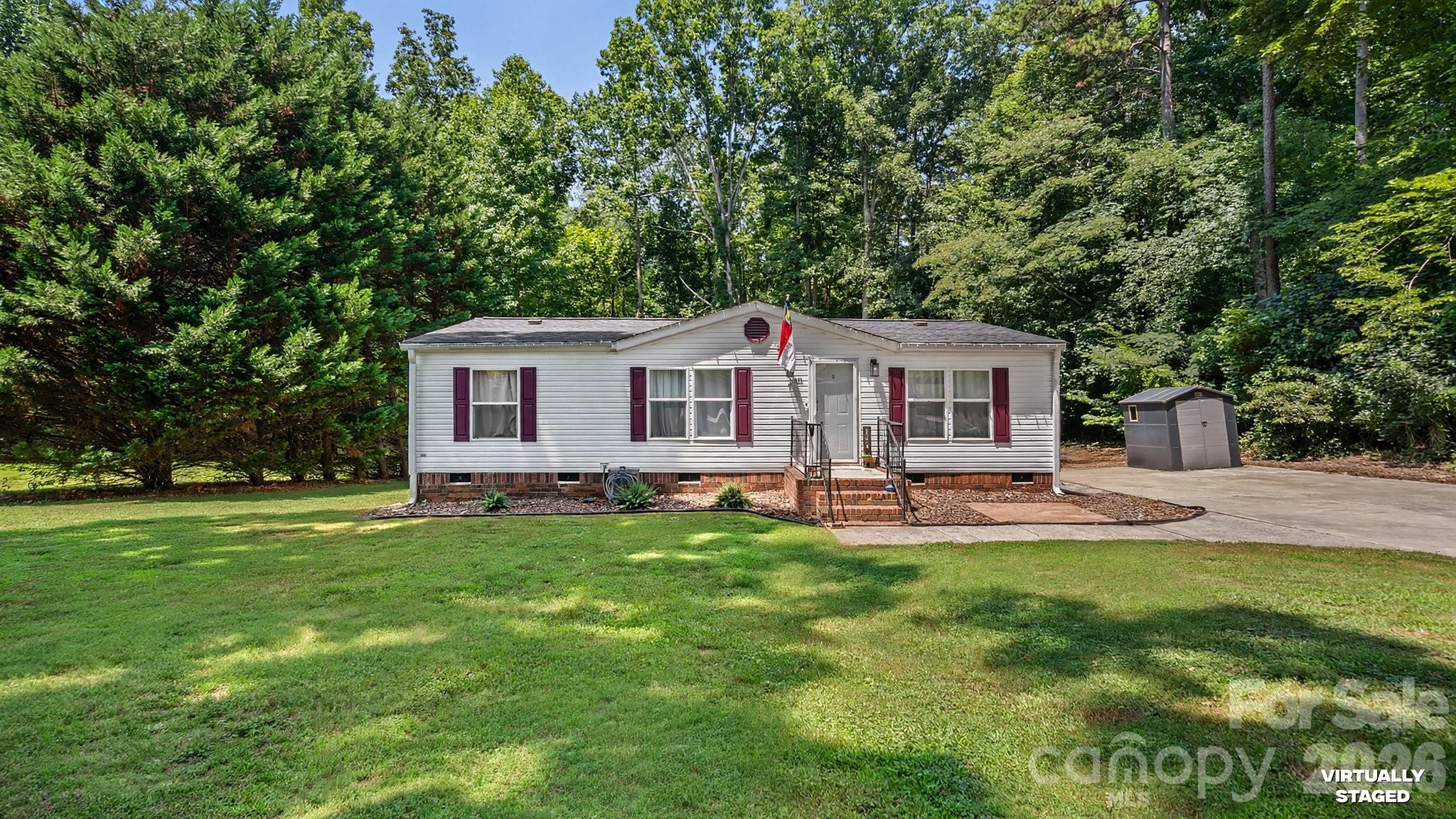 Welcome home to the perfect blend of peaceful country living and modern convenience. Ideally located just outside the Mooresville city limits, this charming property offers the benefit of county taxes while keeping you just minutes from shopping, dining, schools, and Lake Norman.

Inside, you'll find thoughtfully renovated bathrooms and beautiful new flooring throughout, creating a fresh, move-in-ready interior.Step outside to your own backyard retreat, where you'll find raised garden beds producing herbs, tomatoes, beans, and peppers, a greenhouse for year-round gardening, a chicken coop ready for your flock, and two storage sheds that provide plenty of space for tools, hobbies, and outdoor equipment. Whether you're dreaming of a thriving garden, a homesteading lifestyle, or simply a quiet place to call home, this property offers endless possibilities. Once you arrive, you'll understand why it's so easy to fall in love.