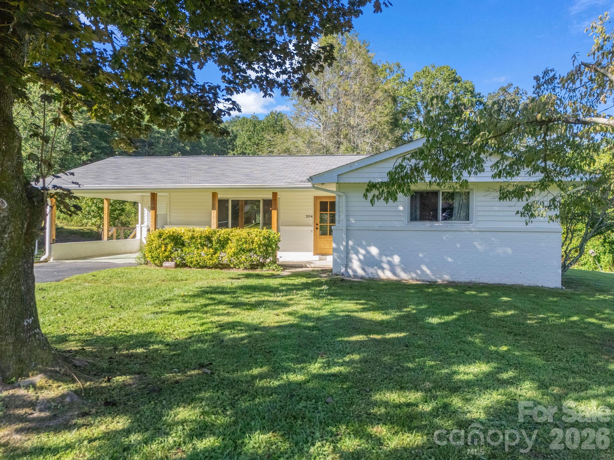 Beautifully updated, move-in ready home with *direct access* to the Ecusta Trail, tucked away on a quiet street. Ideally situated midway between Hendersonville & Horse Shoe.

Tucked away on a quiet dead-end street, this thoughtfully renovated one-level home offers a compelling blend of privacy, natural beauty, and everyday convenience, with direct access to the beloved Ecusta Trail. Surrounded by lush greenery and peaceful creekside scenery, while remaining only minutes from Downtown Hendersonville, the Village of Laurel Park, and budding town of Horse Shoe.

Nearly every aspect of this 3-bedroom, 2.5-bath residence has been thoughtfully updated with an emphasis on quality craftsmanship, comfort, and long-term peace of mind. Fresh, modern, and inviting throughout, the interior showcases quartz countertops, a farmhouse sink, stainless steel appliances with a gas range, designer accent walls, all new flooring and updated interior doors, creating a warm and cohesive aesthetic.

The outdoor spaces have been equally well curated for both relaxation and recreation, featuring a reimagined creek bed designed for easy access to the water and the trail beyond. The generous, level backyard offers ample space for gardening and gathering, or simply enjoying the natural setting, while the beautifully coordinated storage shed adds both charm and functionality to the outdoor living experience.

Additional highlights include city water service without city taxes, along with a private well ideal for gardening or supplemental outdoor use. With both short-term and long-term rentals permitted, this property offers exceptional flexibility as a primary residence, mountain retreat, or investment opportunity in one of Henderson County’s most desirable areas. Minutes from area shopping, dining & renowned local hospital.