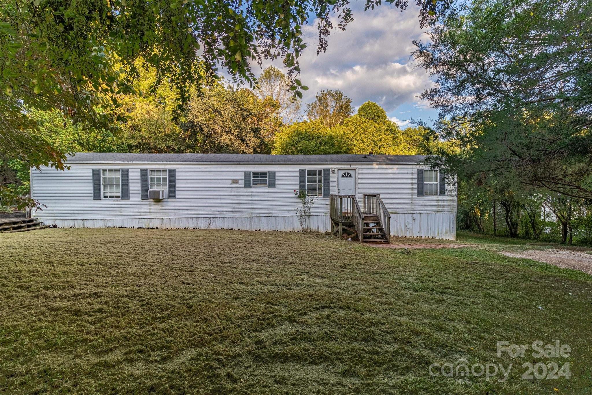 Escape to the tranquility of country living in this charming 2 bedroom, 2 bathroom single-wide mobile home, set on nearly 4 acres of beautiful countryside! This cozy home is ideal for anyone seeking peace and privacy. Enjoy your mornings or evenings on the lovely side deck, perfect for sipping coffee, grilling, or simply soaking in the sun. Inside, you'll find a welcoming layout with an open living area with two spacious bedrooms and two bathrooms. Having almost 4 acres to call your own, there's endless potential for outdoor activities, hobbies, or just enjoying wide-open spaces. Don’t miss this opportunity to own your slice of countryside bliss! The home is located one hour away from Charlotte and 45 minutes to Winston-Salem.