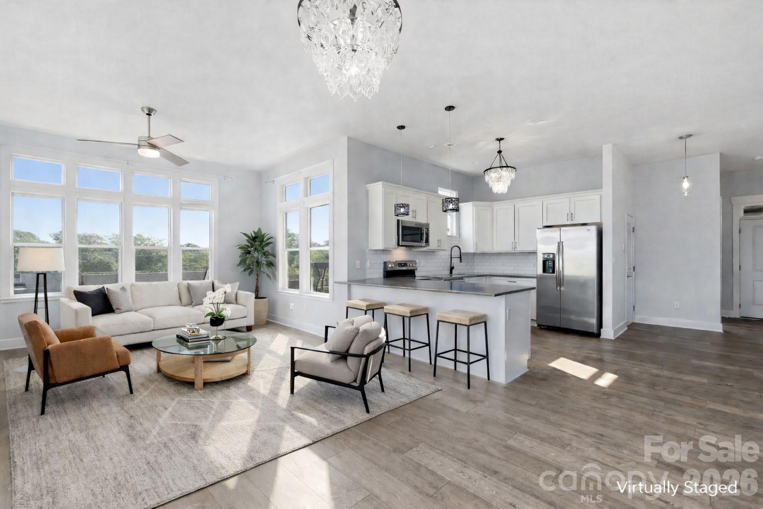 Like-new, top-floor END unit offering impressive Charlotte skyline views from both the private balcony and sun-filled living spaces. With 1,202 square feet — approximately 30% larger than many units in Cotswold Springs — this 2-bedroom, 2-bath condo truly lives large.

The open, flexible layout is filled with natural light and designed for both everyday living and easy entertaining. The kitchen stands out with quartz countertops, soft-close cabinetry, stainless steel appliances, subway tile backsplash, spacious pantry, and an oversized breakfast bar.

The primary suite feels like a true retreat, featuring private balcony access, a walk-in closet, and a spa-inspired bath with an oversized walk-in shower and double quartz vanity. The secondary bedroom easily accommodates a king-sized bed, while the guest bath offers a soaking tub and custom sliding door.

The expansive living area adapts beautifully to your lifestyle — ideal for a great room, dining area, work-from-home setup, or combination of all three. Large windows flood the space with light while framing skyline views beyond.

Step outside onto the private balcony for morning coffee or unwind in the evening as the Uptown skyline begins to glow.

Additional features include:
• Washer, dryer, and refrigerator included
• Fresh neutral interior
• Move-in-ready condition
• 10-foot ceilings
• Krono Swiss flooring
• Dimmable recessed LED lighting throughout

Ideally located between sought-after Cotswold and vibrant Oakhurst, just minutes from Uptown, SouthPark, and Cotswold Shopping Center with easy access to dining, shopping, parks, and entertainment.