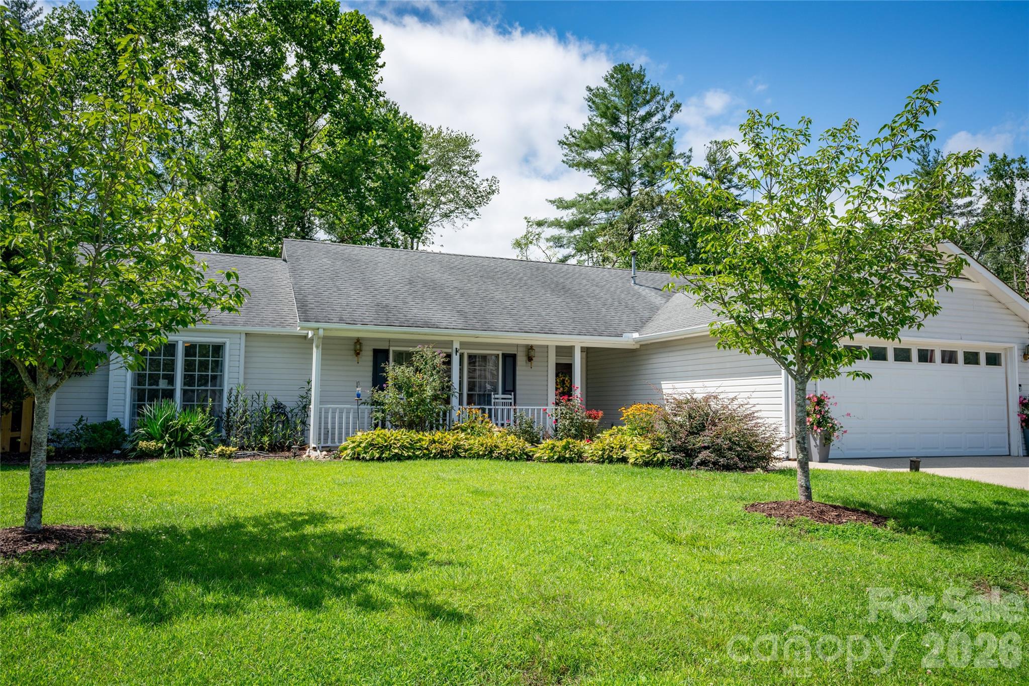 Welcome to this beautifully maintained Fletcher home, where comfort, privacy, and everyday ease come together effortlessly. Tucked away on a quiet cul-de-sac in a no-fee community, this move-in-ready property offers the best of both worlds—just minutes to everything, yet peacefully surrounded by mature trees and lush, established gardens. Inside, a bright and airy split-bedroom floor plan creates both flow and function. Cathedral ceilings in the living room and primary suite add volume and light, giving the home an open, inviting feel. Every space has been thoughtfully cared for, making it easy to settle in from day one. Step outside and you’ll find a flat, usable yard framed by greenery and seasonal color—your own private retreat. The sunny patio is perfect for morning coffee, evening grilling, or gathering with friends, while the fire pit invites relaxed nights under the stars. With its ideal location, charming setting, and no HOA restrictions, this is the kind of home that simply feels good the moment you arrive.