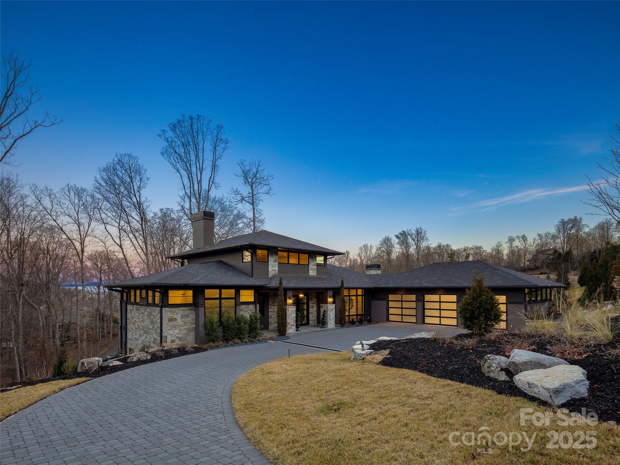 Step into an extraordinary masterpiece of modern luxury, where breathtaking mountain vistas and impeccable design converge. From the moment you arrive, the striking entrance sets the tone for the impressive elegance that awaits inside. Designed for those who love to entertain, this residence boasts an expansive open floor plan, floor-to-ceiling windows that flood the home with natural light, and large screened porches on both levels. The stunning chef-inspired kitchen is a culinary dream, outfitted with top-of-the-line appliances, custom cabinetry, and a vast island perfect for gathering. The main level primary suite is a serene retreat featuring exquisite finishes and a spa-like bath. Downstairs, the thoughtfully designed lower level offers a spacious family room and three well-appointed en-suite bedrooms. A true sanctuary of style and comfort, this remarkable home blends grand design with warm, inviting spaces—an entertainer’s paradise set against an unforgettable mountain backdrop.