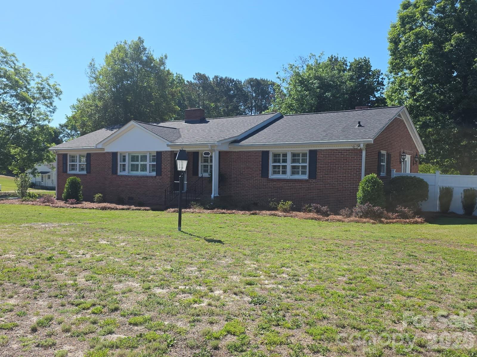The interior of this brick ranch located on a 1.54 ACRE corner lot was extensively updated in 2022 and is ready for a new owner! It is within walking distance of Pageland's downtown area amenities and features updated kitchen with island and SS appliances. The adjoining breakfast area is a pleasant spot to enjoy your morning coffee. The split bedroom plan affords plenty of privacy for the primary bedroom/sitting area and oversized en suite bathroom.  The living room has a cozy fireplace with gas logs that adjoins the dining room. Both areas feature the beautiful original hard wood floors. There is a rear covered deck for your outdoor enjoyment and a double carport with breezeway access to the rear entry.