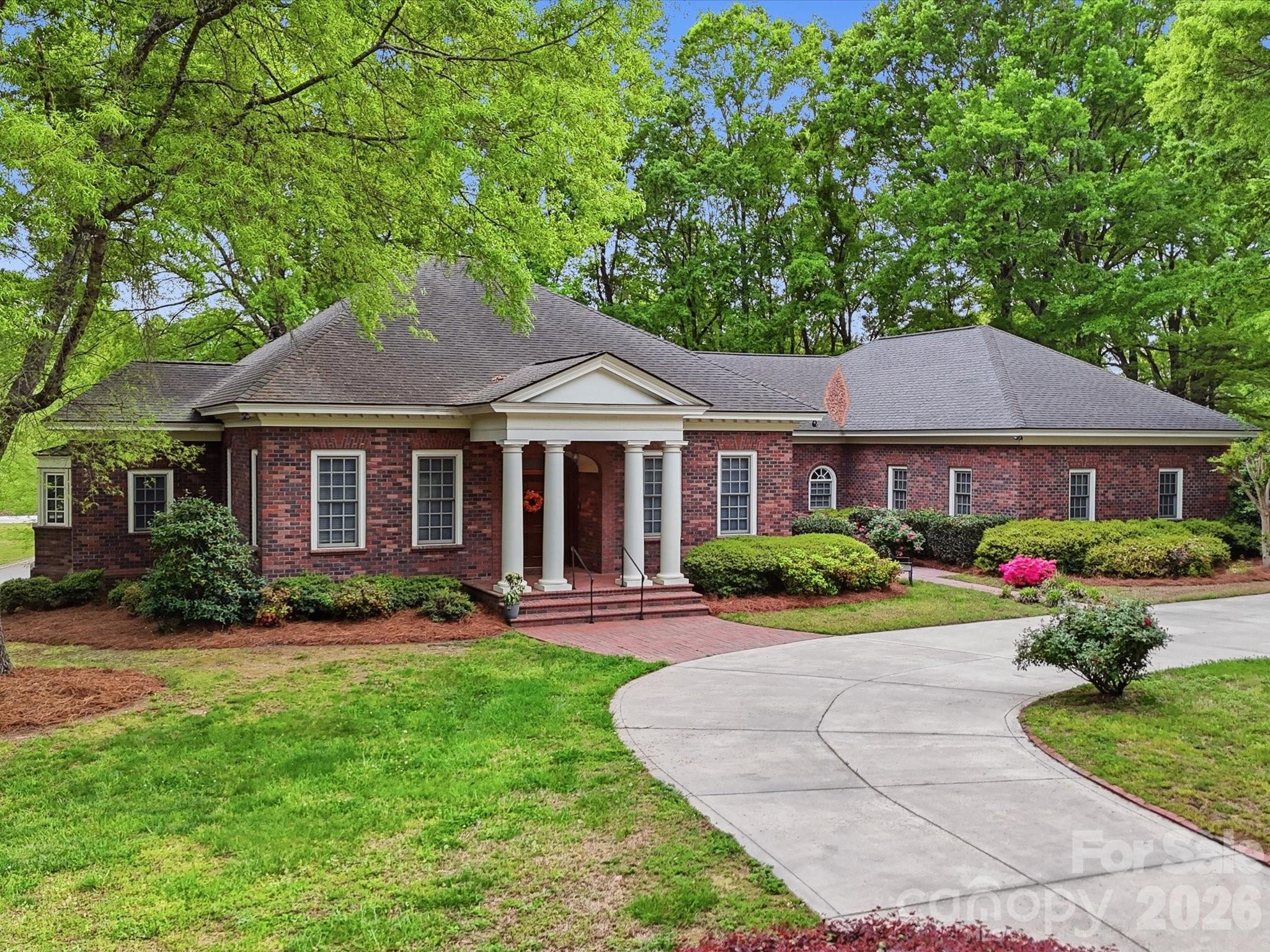 A rare opportunity to own a custom-built, solid brick ranch showcasing timeless craftsmanship, thoughtful design, and peaceful lake views in desirable Lakeview Estates. Situated on a private, wooded corner lot, this home makes a stunning first impression with a sweeping curved driveway, mature landscaping, and a substantial solid wood front door with decorative leaded glass insert set within an arched entry.
This home reflects true quality construction rarely found today. Inside, you will find extensive millwork, stain-in-place hardwood floors, and a creative architectural design featuring arches, curves, and transom windows that carry a cohesive style throughout the home. Natural light fills the open floor plan, highlighting the home’s pristine condition and well-maintained interiors.
Designed for both comfort and accessibility, this ranch home offers wide hallways, multiple zero-entry points, and ADA-compliant features throughout.
The layout includes 3 bedrooms plus a dedicated office with closet that can easily serve as a 4th bedroom, with additional adjoining space that could accommodate a future bathroom or secondary office (see floor plan). The primary suite features dual vanities, a jetted soaking tub, walk-in shower with seating, and generous storage.
The kitchen opens to the main living areas and offers beautiful lake views, built-in oven/microwave, walk-in pantry, and functional layout ideal for everyday living and entertaining. The spacious family room flows seamlessly into a large Four Seasons sunroom with tile flooring and views of the lake.
Outdoor living continues with a circular brick patio that mirrors the home’s architectural curves, while the protected lot across the street helps preserve the lake view.
Car enthusiasts, hobbyists, or those needing extra storage will appreciate the 4-car garage setup, including a 2-car attached garage, a separate single-bay attached garage that is fully heated and cooled via the home’s HVAC system (not a standalone unit), and an additional detached single garage ideal for a boat, golf cart, or lawn equipment.
An unfinished space above the garage offers excellent potential for future expansion. Plans for stair access are available and the space is easily accessible from the end of the hallway.
No pets have ever lived in the home, contributing to its exceptionally clean and pristine condition. Neighborhood being set up for fiber and moving down the street to this house.  
Conveniently located near the growing downtown area of Monroe with dining, shopping, and community events, and with easy access to major highways and Charlotte Douglas International Airport.
Too many features to list. Please refer to the “Features of This Home” document attached in MLS for a complete overview of this truly special property.