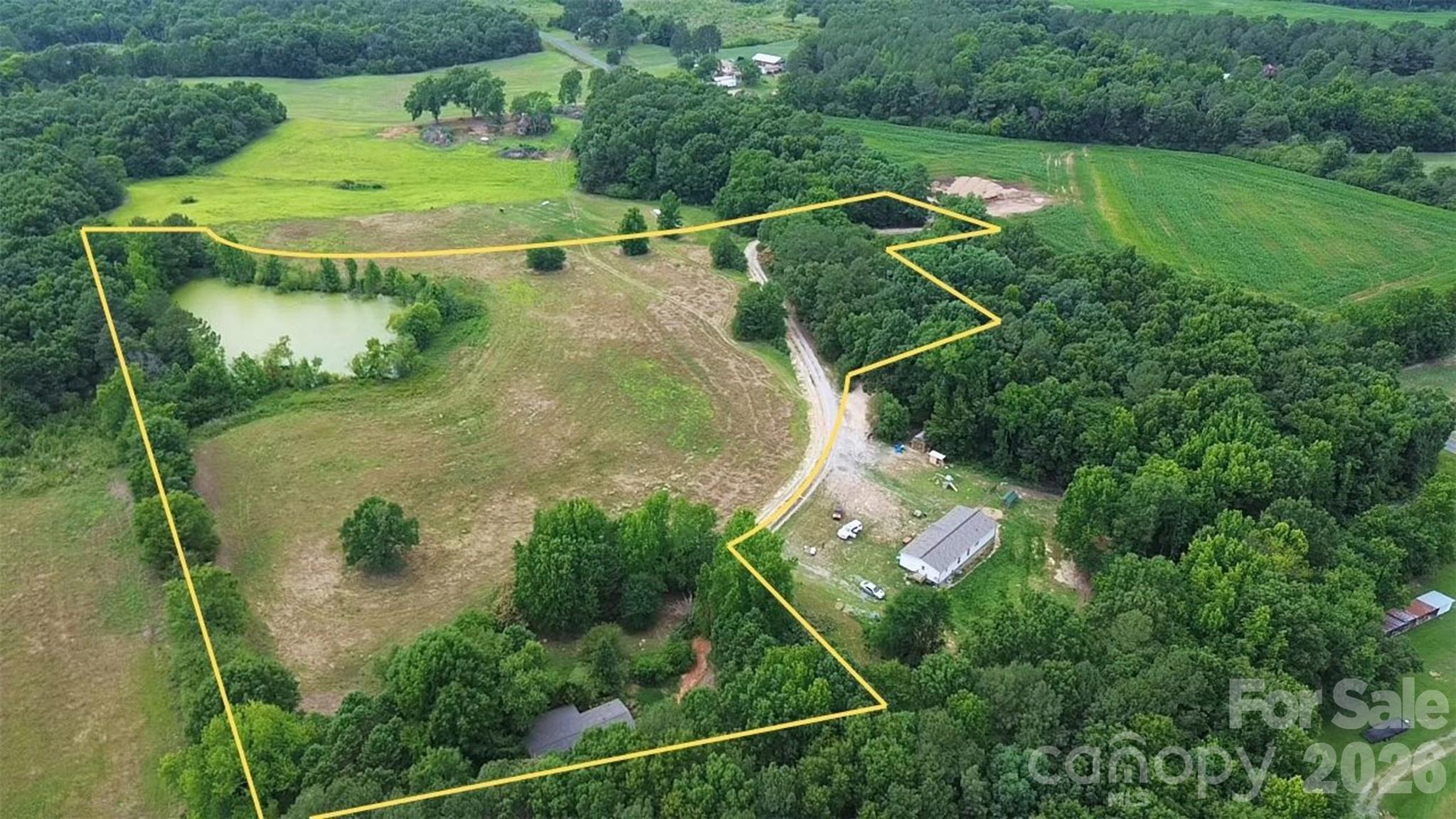 8.18 Acres with Pond, Pasture & Renovation Opportunity – Easy Charlotte Access
Discover the potential of this beautiful 8.18-acre property with convenient access to Charlotte via Hwy 74 and the Monroe Bypass. A winding driveway leads to a private homesite nestled among mature trees, overlooking open pastureland and a farm pond.
The property includes a 1,152-square-foot manufactured home featuring 3 bedrooms, 2 bathrooms, a split-bedroom floor plan, wood-burning fireplace, brick underpinning, and covered porches. The interior has been cleared, providing a clean slate for your renovation vision.
Recent improvements include a roof installed in 2026 with a transferable 5-year workmanship warranty, along with a new county water connection that was installed and fully inspected in 2026. The home is served by a permitted septic system.
The mostly cleared acreage was previously farmed and offers an excellent setting for a future homesite, helping reduce many of the costs and uncertainties often associated with raw vacant land. Existing infrastructure, including the driveway, water connection, septic system, and homesite location, provides a head start for a variety of future plans.
Renovate the existing manufactured home for your own use, or explore its potential as a temporary residence while building a new home, subject to all applicable approvals and requirements. Once completed, the existing home may offer future rental or guest-use possibilities.
With open pasture, mature trees, and a pond that could become a great fishing spot with some cleanup, this versatile property is well suited for a country retreat, homestead, mini-farm, recreation, or horses and livestock.
Sold as-is. Bring your vision and make it your own.