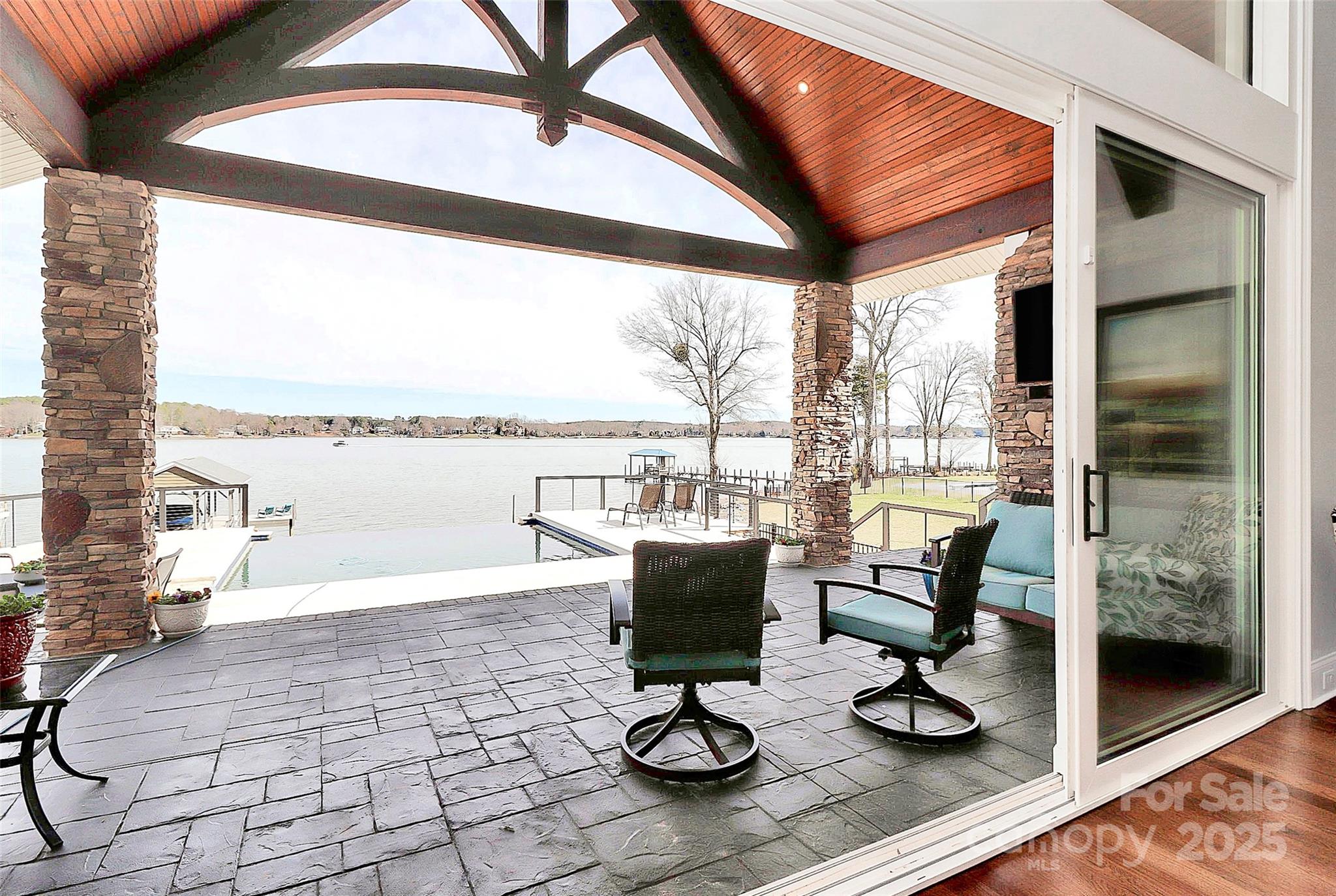 Beautiful, waterfront home. Enjoy the lake life in this 4534 sq ft home located on Lake Norman's main channel with stunning long range views from nearly every room. Beautiful custom real timber beams greet you as you enter and extend onto the covered porch. This home is made for entertaining with sliding doors located in the living area, office and primary bedroom that open directly to the porch and pool deck, complete with spa and infinity pool. Upgrades throughout in this builder's personal home. No HOA fees in this quiet community. 3 BR, 3 1/2 bath with office, flex areas and large loft area upstairs. Enjoy the functionality of the beautiful custom primary closet complete with vanity, window seat and large island.  Over 460 square feet of unfinished area above the garage for future expansion or storage. The large 3 car garage has hard-coated flooring, and a large parking area for a multitude of guests. Private dock with boat lift and a private boat ramp located on the property.