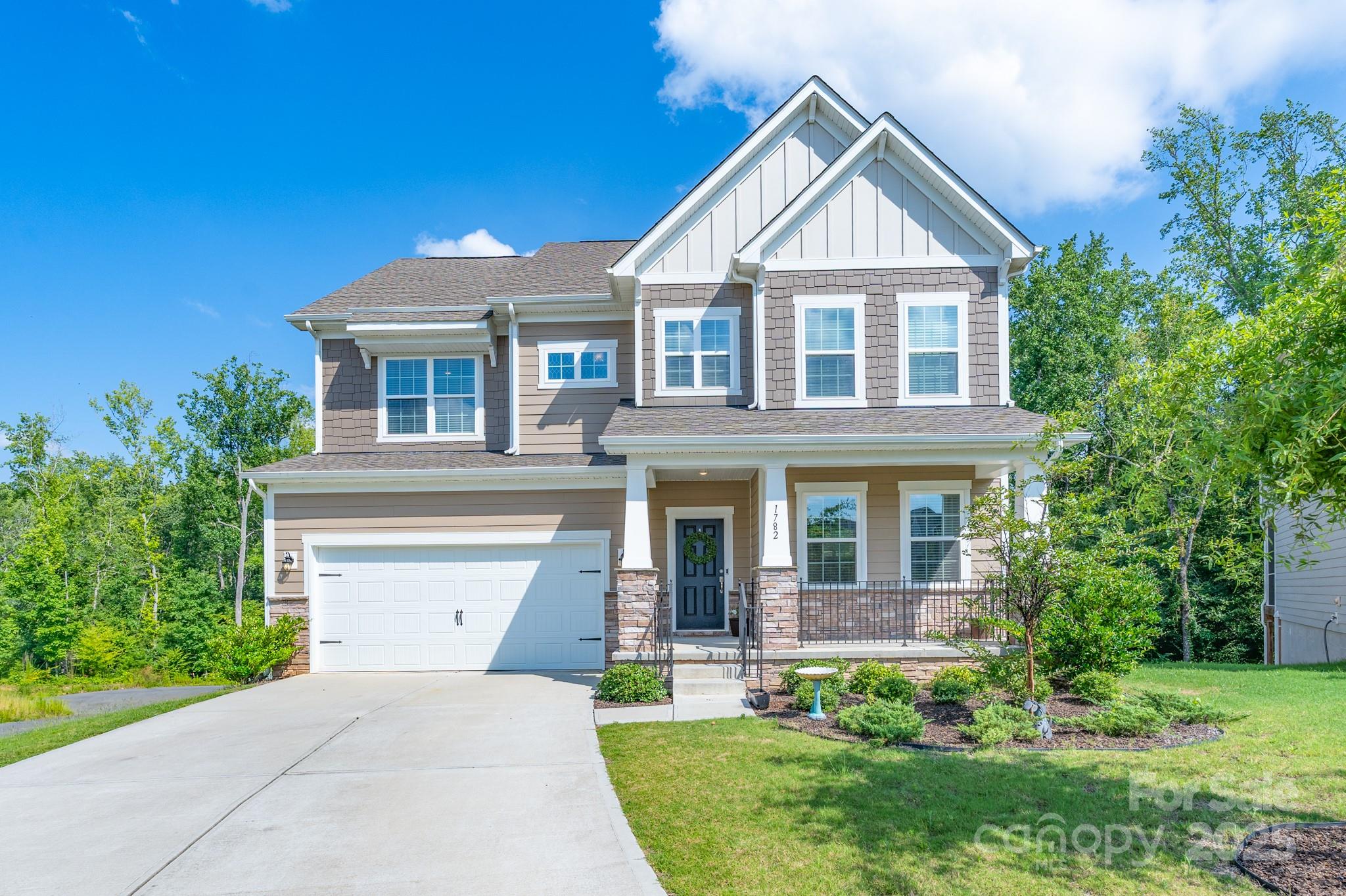 Welcome to this beautifully crafted basement home nestled at the end of a cul-de-sac, backing to serene woods. In the desirable Windhaven, this light-filled home offers a modern open floor plan and thoughtfully designed spaces perfect for everyday living and entertaining. A large, welcoming front porch sets the tone as you enter. The main level features a home office with elegant French doors, a chef's kitchen, a guest suite with a full bath, and a deck. Upstairs, you'll find a luxurious primary suite, a secondary bedroom with a private bath, two additional bedrooms, a hallway full bath, and a laundry room. The partially finished walkout basement is a huge bonus, with plumbing already in place for a full bath and kitchen, offering tremendous flexibility. The space also includes a custom workshop with a charming barn door. Whether you complete the basement or enjoy it as-is, it adds substantial value and room to grow. Enjoy the lifestyle and amenities of Tega Cay with quick access to I-77, top-rated schools, and low SC taxes.