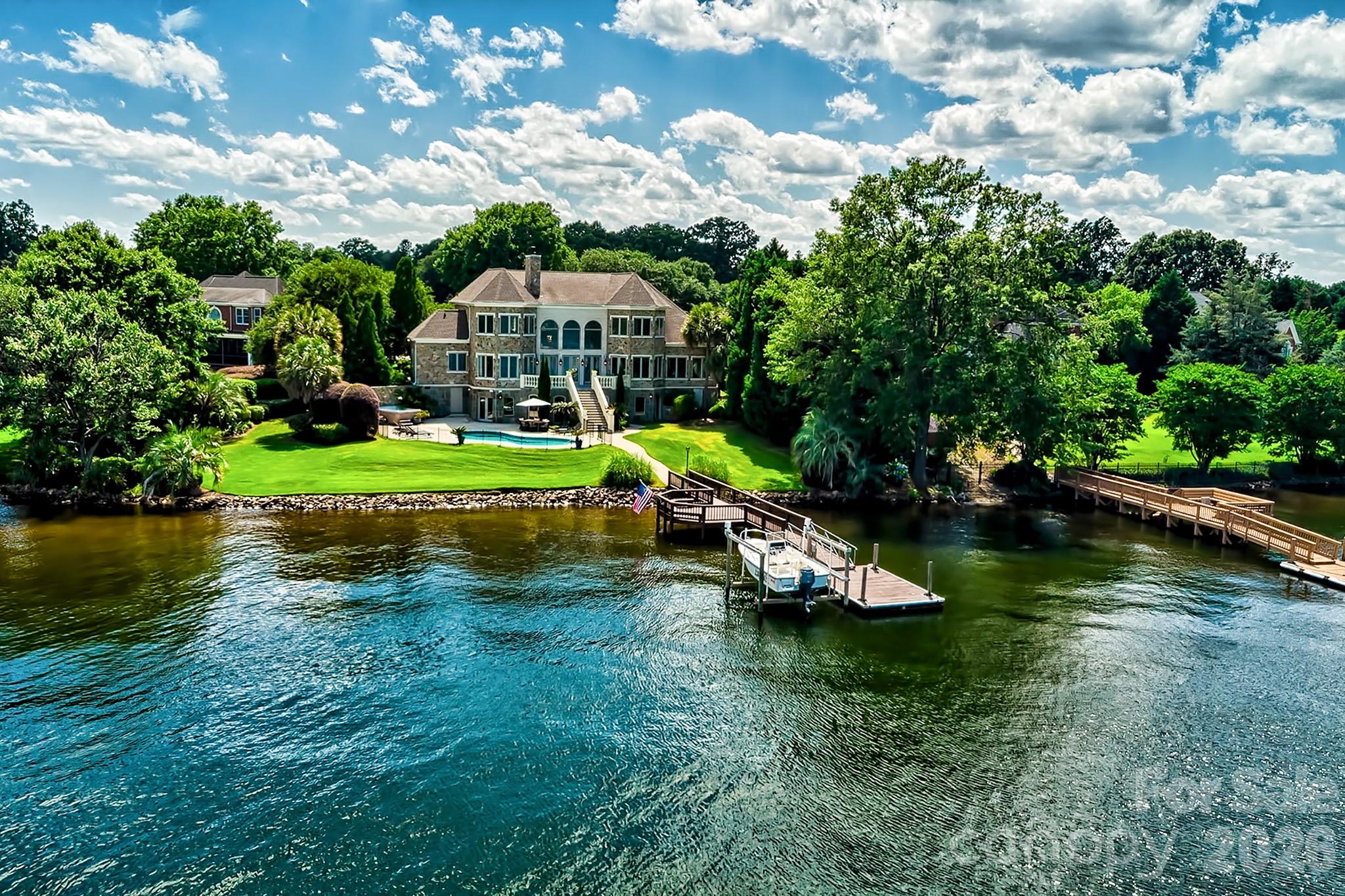 Back on Market to NO FAULT OF THE SELLER! Perched on the most coveted lot in the prestigious gated community of Spence Plantation, this one-of-a-kind waterfront estate offers a lifestyle of unrivaled privacy, exclusivity, and luxury. Constructed entirely of premium natural stone and spanning over 6,700 sq ft across 3.5 meticulously designed levels, this architectural masterpiece commands attention with panoramic, unobstructed lake views from every room and over a MILLION DOLLARS in upgrades. Your private resort awaits; Every day feels like an opulent vacation—set on 215 ft of prime shoreline with breathtaking, oceanesque views. Float in the saltwater pool, unwind in the hot tub spa or sauna, or walk out on your updated dock with convenient boat lift, all from the comfort of your own backyard. Tucked at the end of a quiet cul-de-sac, the home is surrounded by lush, mature, professional landscaped grounds that offers unmatched seclusion. A custom brick-laid driveway flanked by majestic live oaks leads to an estate that feels worlds away-yet is just minutes from everything! Inside, 20' soaring ceilings, 12” crown molding, & wall-to-wall water views elevate the elegance. The recently updated gourmet chef’s kitchen features a built-in SubZero fridge, Dacor gas cooktop & double ovens, extensive cabinetry, & a massive walk-in pantry. There is no shortage of cabinetry or countertop space. The luxurious primary suite is a private sanctuary with stunning lake views, French doors opening to the terrace, custom mechanical blackout shades, and a completely remodeled primary en suite featuring dual walk-in closets, dual vanities, custom spa shower, and an oversized jetted soaking tub. Designed for both relaxed living & grand entertaining, the home includes a theater, fitness room, two additional kitchenettes (one on every level), and spacious secondary bedrooms. Every detail has been thoughtfully curated—from renovated baths to abundant storage. This is more than a home- it’s a statement. A sanctuary. A once-in-a-lifetime opportunity to own the most iconic property in the neighborhood, and perhaps on the lake. Come home to the pinnacle of lakefront living. You’ll never want, or need to, leave. Agent related to seller