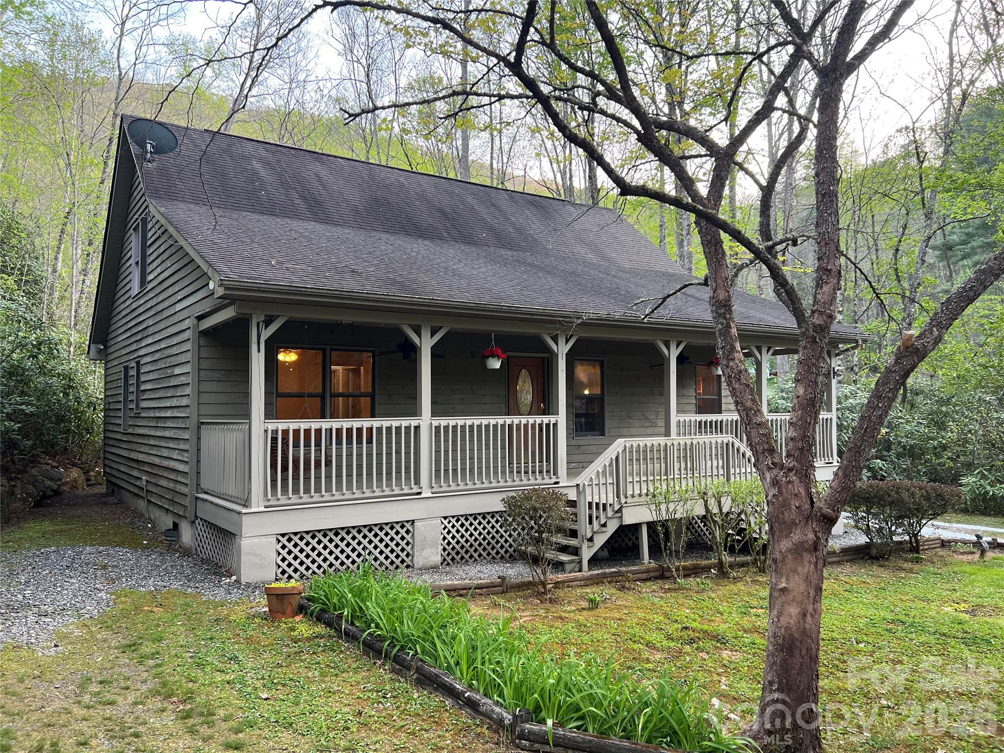 Seller decided to take off the market to have the back deck, outbuilding deck, railings and front steps pressure washed & stained. Back on the market and looking great. Want a Mayberry Community as a second home, vacation rental or full time living? This is it!!! Charming 2 BR 2 BA cabin with open loft great for an office or bonus room. You will enjoy the rocking chair front porch and swing. Listen to the sounds of nature and the soothing calm of the creek as you take in the ideal mountain experience. Walking trails for hiking and for walking your pet. Open floor plan & cathedral ceilings, rock fireplace with gas logs, country kitchen with island & lots of cabinets. Built in bookshelves in the living room and loft. The fenced back yard is great for fun and pets & the 8 x 12 outbuilding was designed as a music/art studio, The front part is a workshop space. Location with easy access to Sylva, Cullowhee, Franklin, Bryson City, Waynesville and Asheville.  For more acreage, adjacent Lot 19 with .90 acres is available at $23,000.  Pin number 7610-71-9090 MLS 4385652