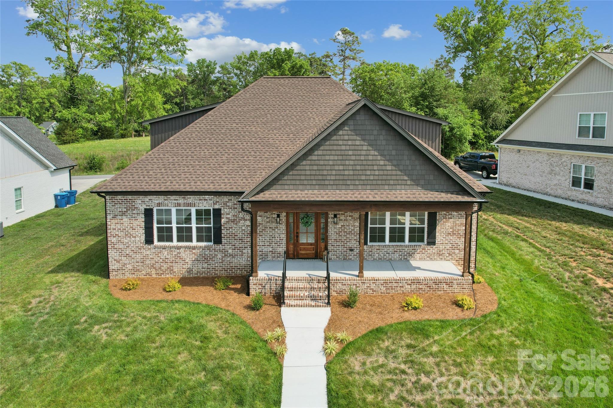 This all brick 2025 new build blends timeless craftsmanship with modern luxury. Step inside to soaring light, an open concept living space anchored by a stunning gas-log fireplace along with a chef-inspired kitchen dressed in quartz, stainless steel appliances and custom cabinetry. Then main level primary suite offers a serene retreat, while two additional upstairs bedrooms provide comfort for family or guests. Relax on the screened -in porch, unwind on the front porch and enjoy the convenience of a two-car garage and low maintenance living. A rare opportunity to own a brand-new home and moments from Mocksville's charming downtown. Come take a look today as builder is offering $5,000 in closing cost with acceptable offer.