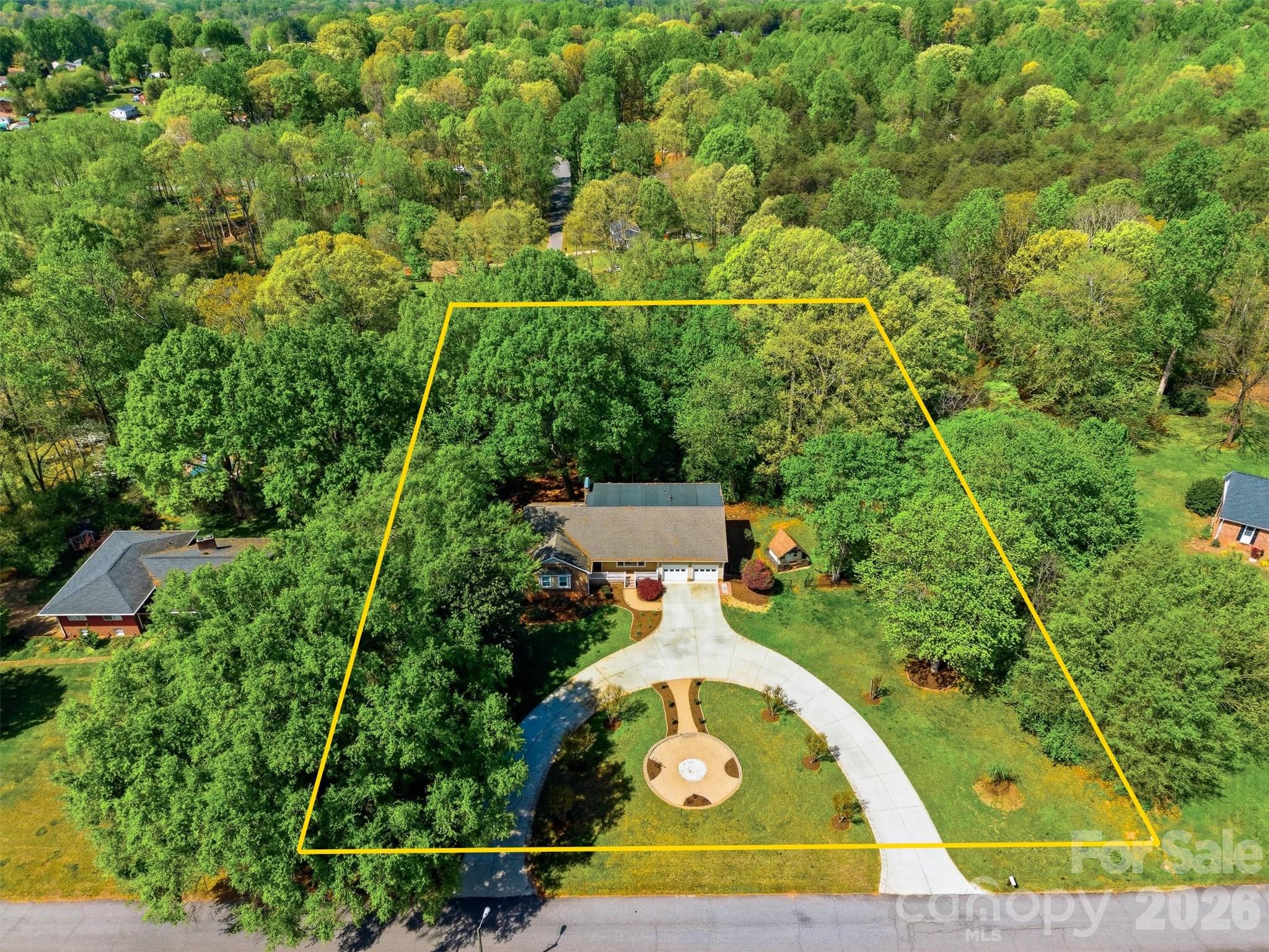 Don't judge this book by its cover! Located just one block from Newton's Greenway Trail, this 5 bedroom, 4 bathroom house offers over 4,460 HSF of tastefully updated living space featuring main-level living for those that need it, plus upper and lower levels for all the perks! A covered front entrance leads into a traditional foyer with adjoining living room with lots of natural light and quaint decorative fireplace accent. From there, you'll find an adjoining great room with a beamed T&G vaulted ceiling, built-ins, fireplace, dining area, and exit to the rear deck. The open kitchen offers plenty of workspace, stainless appliances, gas stove, breakfast area with bar seating, and adjoining sunroom overlooking the backyard. A rear hallway leads to three bedrooms, including a primary suite with deluxe walk-in closet and private bath with tiled shower. The main level is completed by a laundry room with sink and double garage. Upstairs, you'll find a loft office space, walk-in attic storage, and a Jack & Jill bedroom suite with shared bathroom. The lower level was built for fun, featuring a den with wet bar, home theater, full bathroom with jetted tub, bonus room, tons of storage space & 2nd laundry, and exit to the rear yard with putting green, built-in sandbox, patios, and over 1.3 acres of wooded yard to explore!