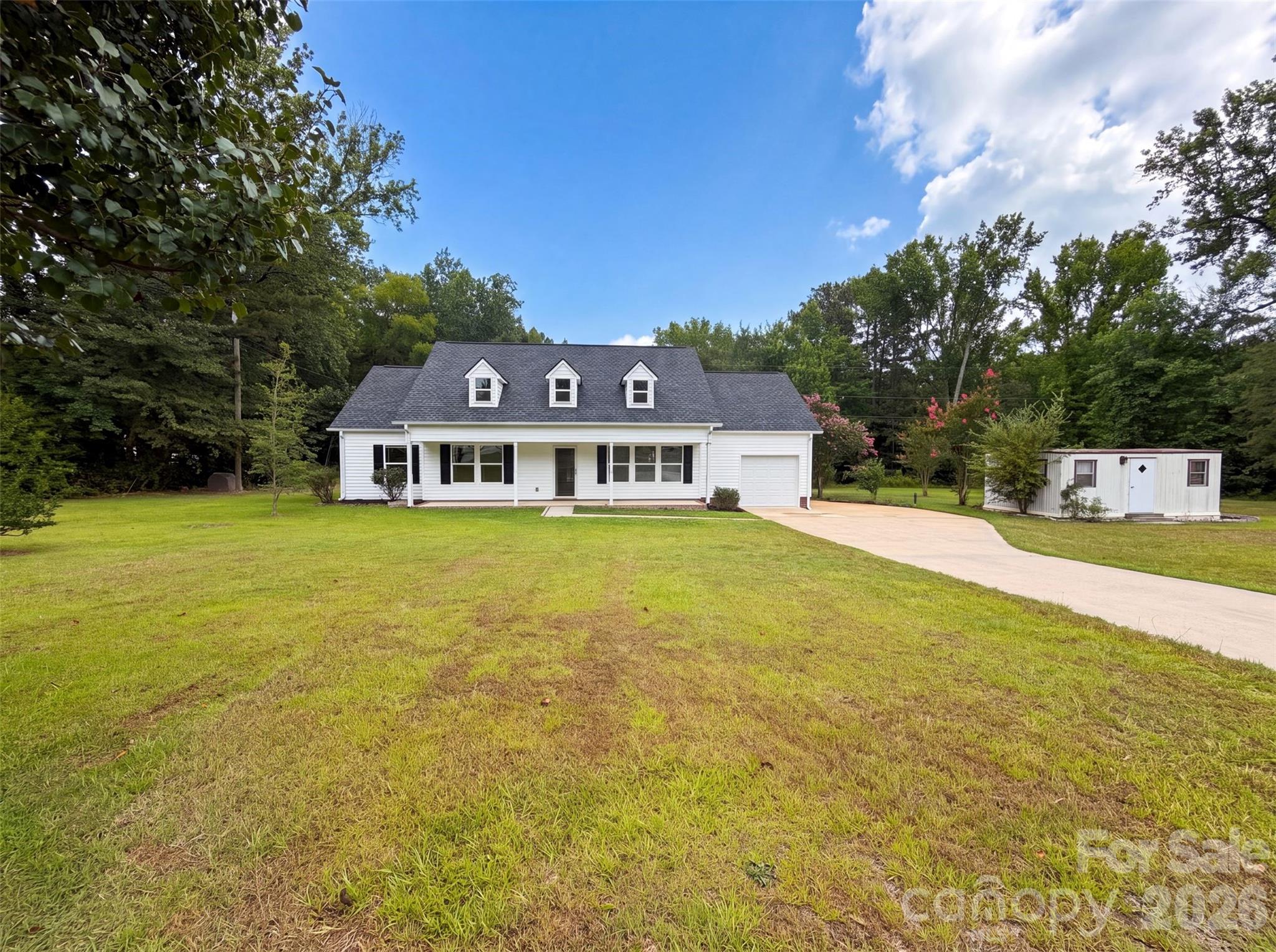 1246 Neelys Creek Rd is a 1-story Rock Hill home set on a large lot. The kitchen features wood cabinetry, stone countertops, and hardwood floors with room for meal preparation. A vaulted great room with a ceiling fan opens to the kitchen, forming the main living space. The primary bedroom includes a vaulted ceiling, a walk-in closet for storage, and an adjoining bathroom with a walk-in shower and double vanity. Additional bedrooms and a full bathroom with a tub accommodate flexible use, and a dedicated laundry room adds convenience. A screened porch and a backyard storage shed extend the outdoor space. Clean interior finishes complete this well-maintained residence throughout.. Included 100-Day Home Warranty with buyer activation (this property has a 3rd room, no closet, so it is listed as an office)