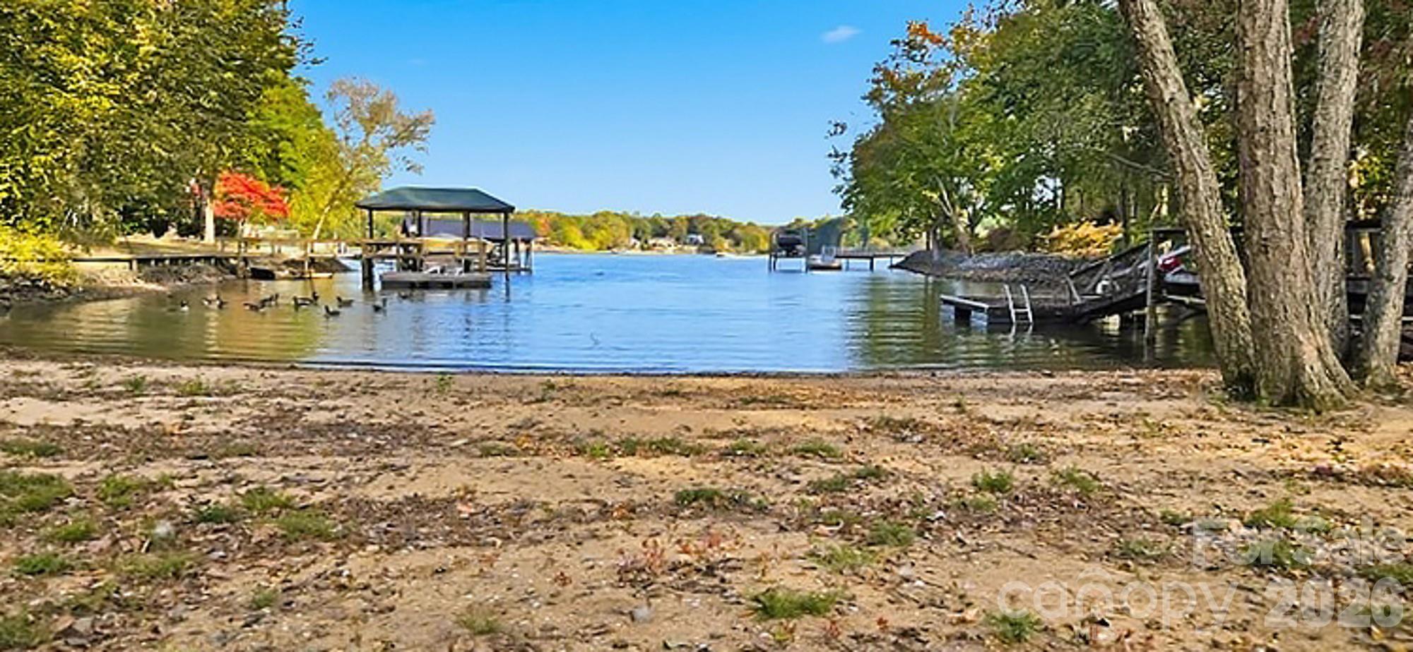 Lake Wylie Waterfront Retreat — Private Cove Perfection.

Discover the best of Lake Wylie living in this stunning waterfront home tucked just off the main channel in a peaceful, protected cove. This desirable level lot offers privacy, natural beauty, and an easy walk to your own sandy beach shoreline and private dock — ideal for swimming, boating, and relaxing lakeside.

Designed for comfort and functionality, the main home features one-level living with an updated primary suite and a spa-like bath, two vaulted great rooms filled with natural light, each with a cozy gas fireplaces. The spacious kitchen boasts a large island, an eat-at bar, and ample cabinetry — perfect for gatherings. A sunroom and wraparound composite deck invite you to soak in the serene lake views year-round.

Upstairs, a bonus room with a full bath offers flexibility for an office, guest space, or game room.

Car enthusiasts and hobbyists will love the massive garage capacity for up to six cars — easily adaptable into a workshop, hobby area, or rec space.

Affectionately known as “The Tree House,” the detached garage offers a second living area, complete with a kitchenette, full bath, and sleeping quarters — making it an ideal guest suite or entertaining space. Step out onto the covered deck and take in the panoramic views of your private waterfront paradise.  Located just ½ mile from the North Carolina border, this home offers the best of both worlds.  Award-winning Clover schools, low South Carolina taxes, and easy access to Charlotte’s International Airport, Uptown Charlotte, and the area’s many dining, entertainment, and medical facilities.

This is Lake Wylie living at its finest — peaceful, practical, and perfectly positioned for everyday convenience and relaxation.