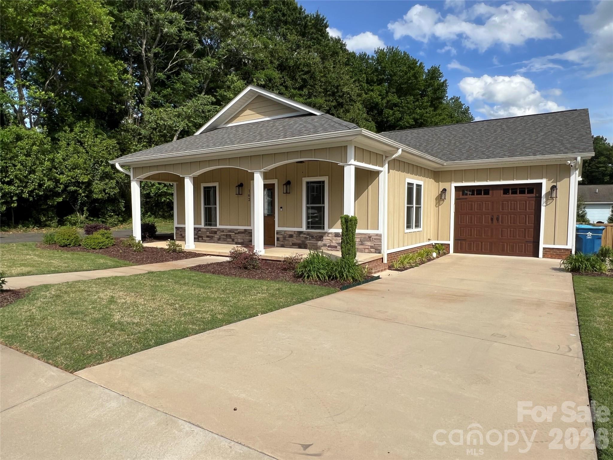 Built in 2022, this home looks and presents like new and offers 2 bedrooms and 2 baths. The primary bedroom has a large bathroom, and the guest bathroom is conveniently located in the hallway next to the guest bedroom. Spacious open floor plan, including a dining area, den with a fireplace, breakfast bar and kitchen. Custom back patio, privacy fence and landscaping. Single car attached garage. Granite countertops, nice cabinetry, and a separate laundry room. All on one-level for ease of living.  Located along the "Thermal Belt Rail Trail", (13+ mile bike trail) and close to municipal golf and a vibrant Forest City downtown.