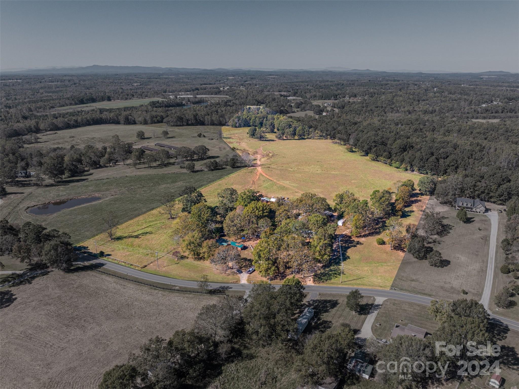 INVESTMENT OPPORTUNITY! Discover a rare haven with limitless potential! This cherished family property for generations, spanning 33 acres, showcases a serene fenced grazing pasture, stunning Sunset mountain views, a brick family single story home, multiple sheds/buildings and five manufactured single-wide home/spaces! Offering approximately 588 feet of road frontage, this invites you to envision a multifaceted investment opportunity: multifamily development, farm, private estate, rentals to add to a rental porfolio, equestrian paradise, or subdivide  and only keep what you want! The fenced pasture, brick house and some trailers are currently rented. Nestled just a few miles from Lincolnton and Cherryville, schools, shopping and the new public libracy, this incredible opportunity awaits your vision to bring it back to its former days! RARE OPPORTUNITY!