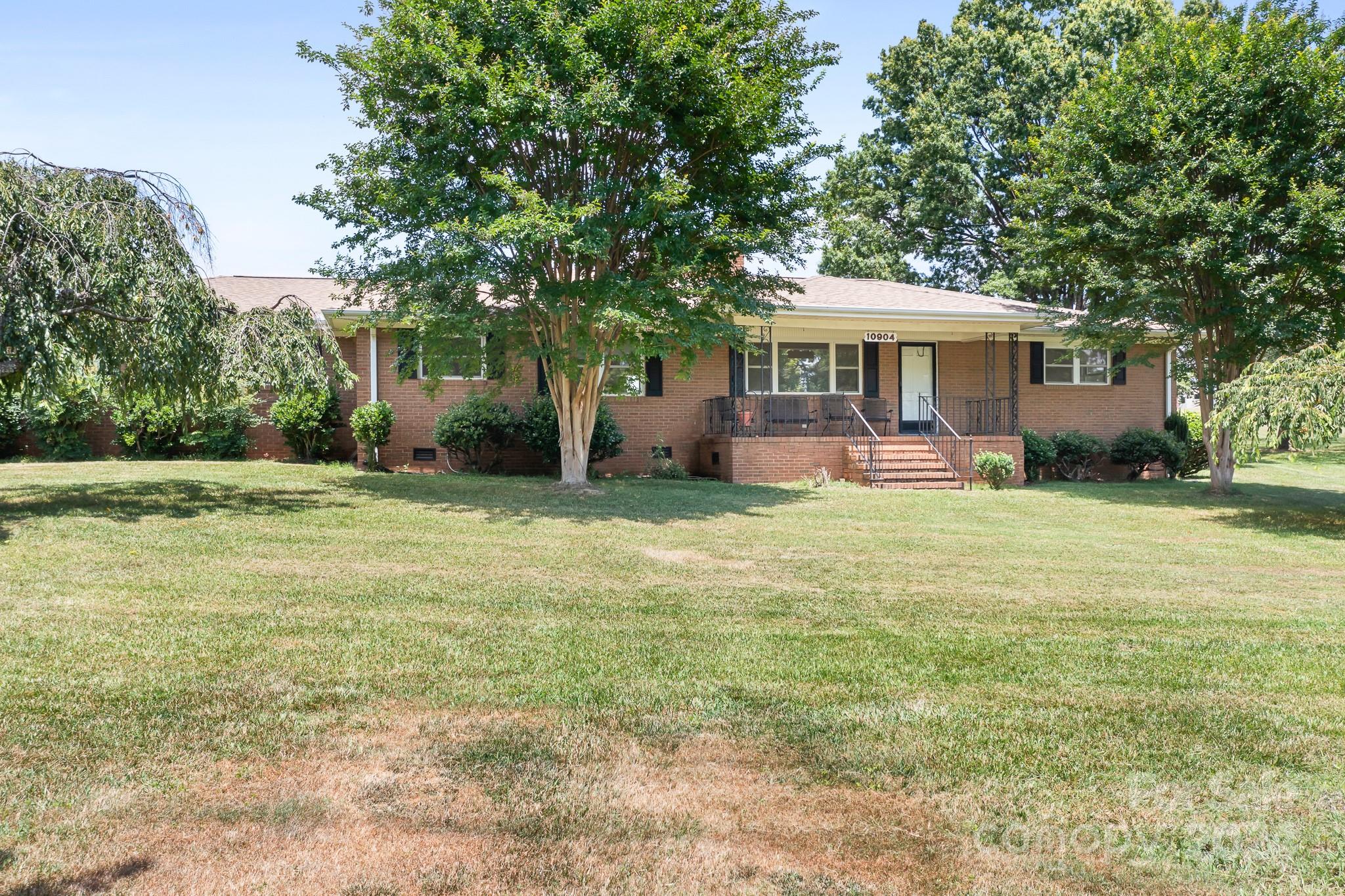 Close to everything, but feels like you're away from it all! Special location that feels rural, but is located minutes to entertainment, shopping, restaurants & interstates. This stately brick ranch is situated on a massive corner lot w/lots of shady trees & plenty of space. There's also a tractor shed on the property w/an extra storage building. Spacious owner's suite w/extended vanity space & lots of natural light.  Two large secondary bedrooms, one w/attached half bath. Welcoming formal living room. Separate den w/wood-burning fireplace. Kitchen w/lots of storage & counter space, new wall oven w/air fryer, cooktop/vent 2023, Dining area adjacent to kitchen. Two car garage w/huge storage rm. Covered front porch overlooking the large front yard, smaller back porch is also covered & opens to paver patio.  Huge backyard perfect for a garden or outdoor entertaining.  Newer vinyl windows. Per seller, water heater installed in 2023 & new Trane heat pump 2022.  Some rooms virtually staged.