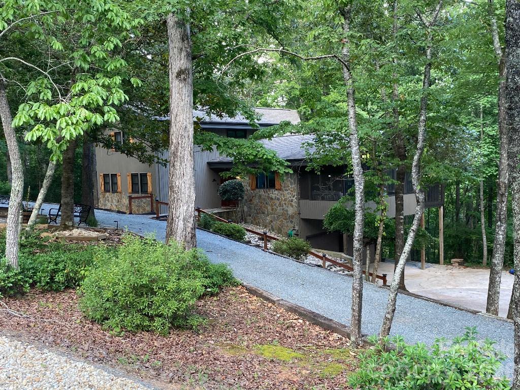 Welcome to this beautifully updated and furnished 4-bedroom, 3-bathroom home, nestled in the serene community of Rumbling Bald, on Lake Lure, NC. Boasting luxurious living space, this property is the perfect blend of modern comfort and elegant design. Interior highlights: Spacious living area with 2 story windows that flood the space with natural light. Gourmet kitchen updated with a sleek 9-foot island, perfect for entertaining. The kitchen also features modern appliances and ample storage. The finished basement was recently completed providing additional living space. Luxurious bathrooms, 2 have been recently updated, including tile floors and contemporary fixtures. Bamboo hardwood floors. An alarm system ensures your safety and peace of mind. Exterior highlights: Cedar siding, finished garage, new circular driveway, propane gas and furnished sale.