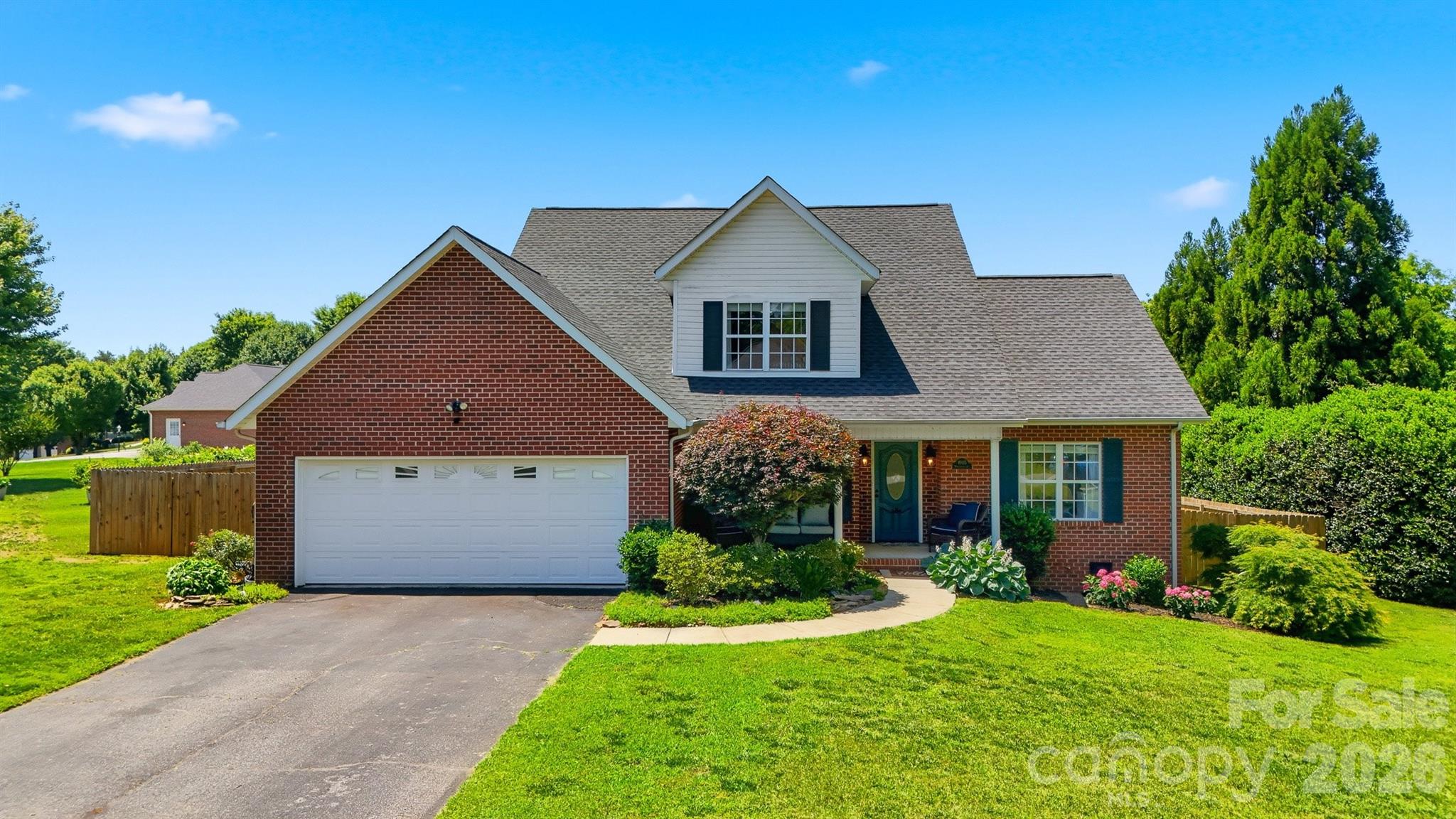Welcome to this beautifully maintained brick home in the Brickfield community of desirable Mountain View. Offering a thoughtfully designed 1.5-story layout, this home features a main-level primary suite, inviting living spaces, and a private outdoor retreat. The covered front porch provides a welcoming first impression and a perfect spot to relax. Inside, the two-story foyer and living room create an open, airy feel, highlighted by floor-to-ceiling windows, abundant natural light, and a fireplace. Hardwood flooring extends throughout the main level, and the formal dining room adds charm with elegant chair rail detailing. The spacious kitchen is well-equipped with granite countertops, a tile backsplash, stainless steel gas range, microwave, refrigerator, breakfast bar, and a built-in desk area. An adjoining breakfast nook offers a comfortable space for casual dining. The primary suite is conveniently located on the main level and includes a walk-in closet and private bath with dual vanities and a walk-in shower. Upstairs are two additional bedrooms and a full bath, providing flexibility for family, guests, or a home office. Outside, the fenced backyard is designed for both relaxation and privacy, featuring a covered patio and mature landscaping. Additional storage is available in the attic above the attached two-car garage. Combining classic appeal, functional living space, and a sought-after location, this home is ready for its next chapter. This property is within 1/2 mile of a voluntary agriculture district.